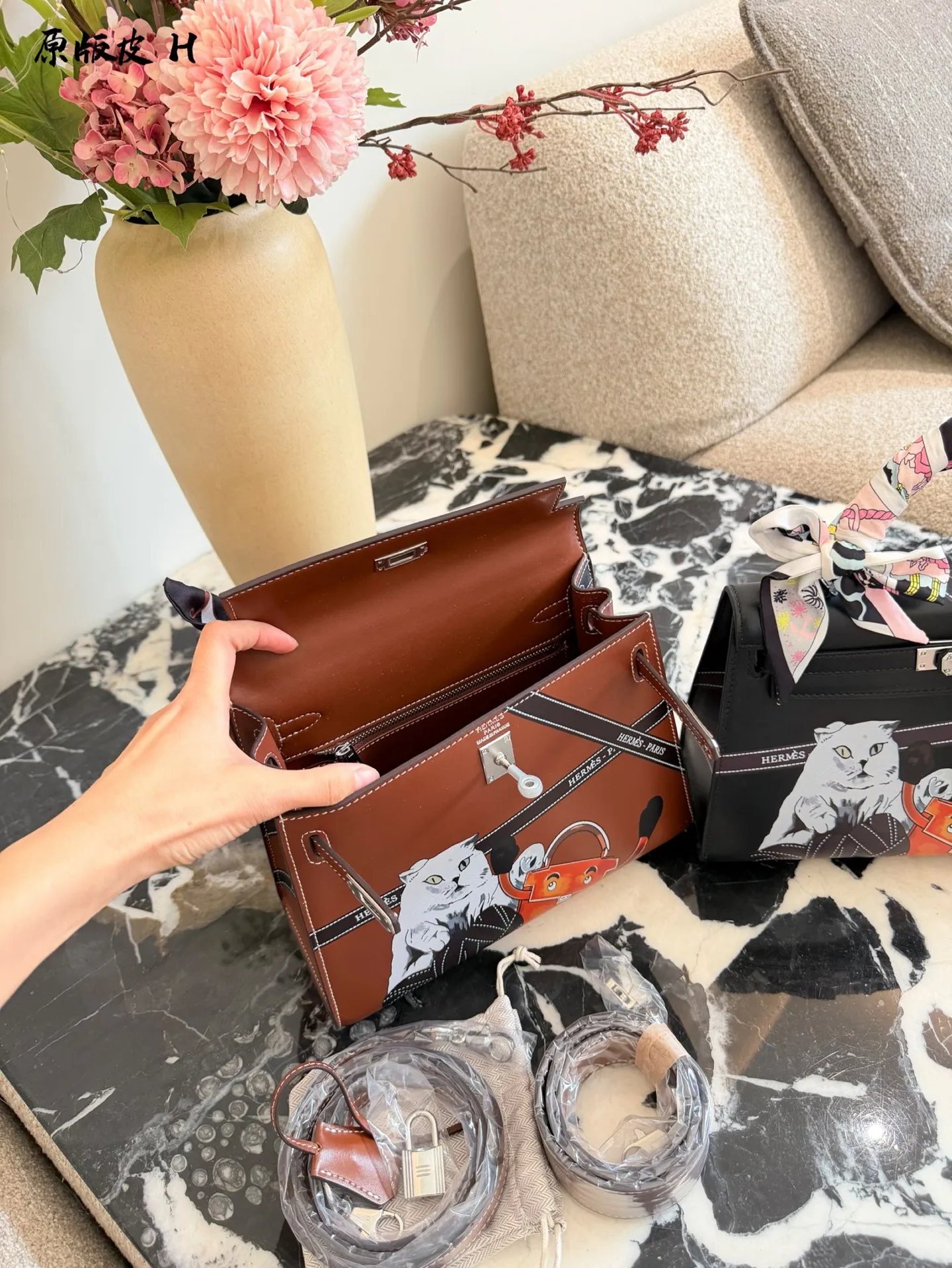 p330 爱马仕彩绘凯莉包 国这款爱马仕Kelly 25彩绘包，采用Epsom牛皮， 耐磨又有型，金扣超精致十。包身猫咪和茶壶图案超有趣，个性满分!25x18x8cm25x18x8cm,通勤出行都很适合。丝巾点缀,优雅又俏皮，搭配小飞马挂件更显趣味，是时尚与艺术的完美结合图。