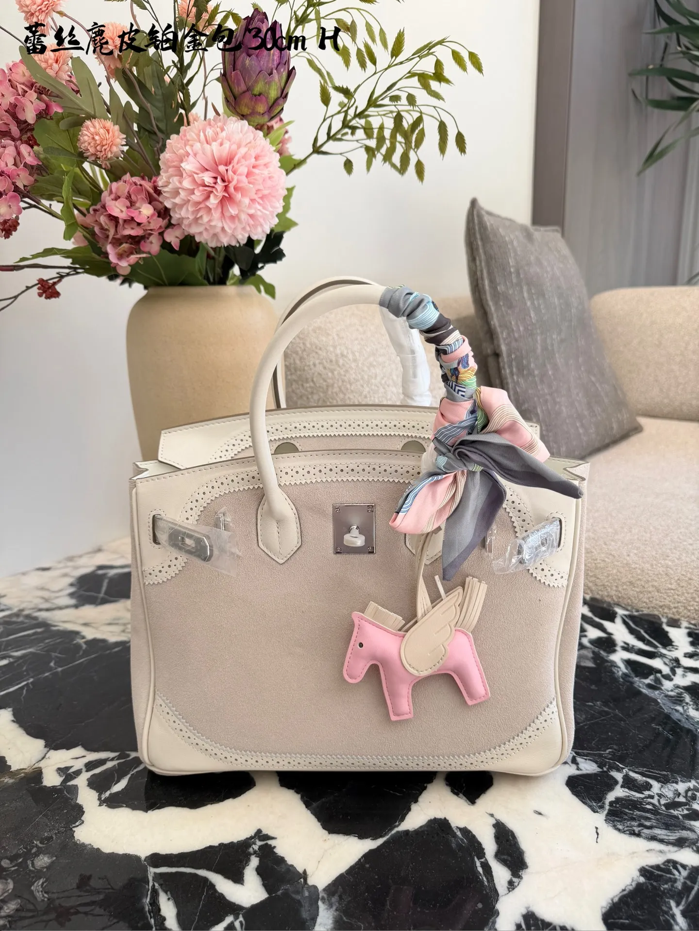 p340 Birkin30珍珠白铂金包｜优雅故事的梦幻逸品 🌙 前任主人的故事 前任主人是资深爱马仕藏家，当初为了重要场合定制这只 Birkin 30，珍珠灰配白银 Swift 皮，蕾丝边装饰更添柔美。后来因个人风格转向极简，虽万分不舍，仍希望它能继续陪伴懂它的人，让这份优雅延续。 💎 设计与品质解析 ✨设计故事：Birkin 系列本就是爱马仕经典传奇，这只珍珠灰配色温柔高级，蕾丝边装饰打破常规，将法式浪漫与铂金包的大气融合，背出街就是 &ldquo;行走的高奢名片&rdquo;。 ✨材质与成色：采用细腻柔软的 Swift 皮，触感如丝绸般顺滑；珍珠灰配色高级不挑人，白银金属扣精致闪耀。成色近乎闲置未使用，五金无氧化，皮质无磨损，宛如全新。 ✨尺寸与实用度：30*15*21.5cm 黄金尺寸，日常通勤能装下平板、钱包、化妆品；出席晚宴、商务场合，随手拎起即刻提升气场。