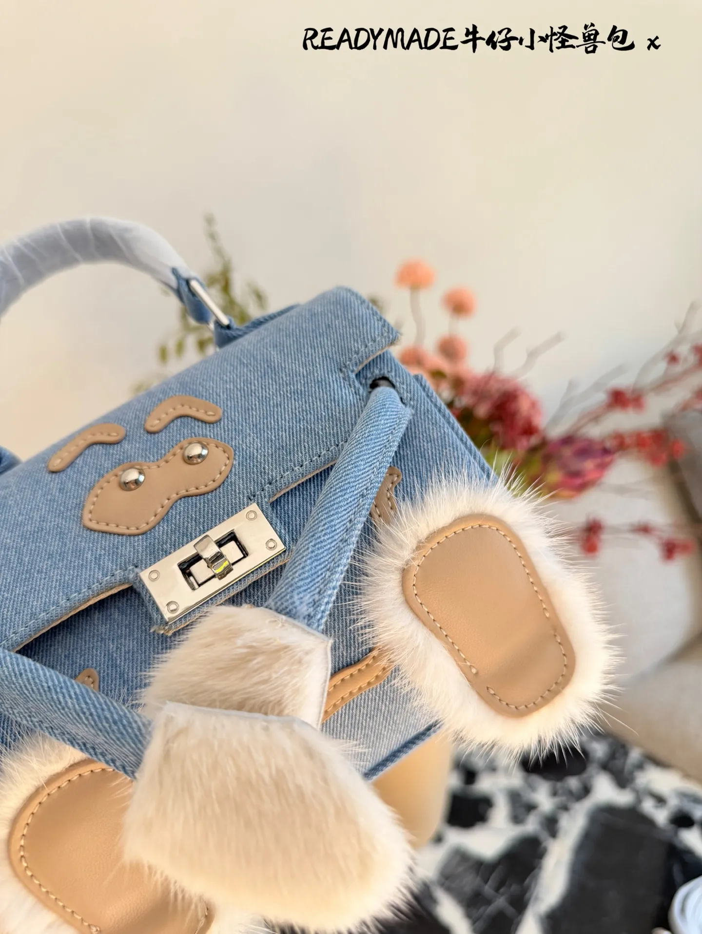 p215 READYMADE牛仔小怪兽包 国日本小众品牌READYMADE的牛仔小怪兽包,灵感来 自爱马仕Kelly Doll,浅蓝牛仔布+貂毛手脚,手感超柔软,趣味满分汁。迷你尺寸约18cm,能装手机、气垫等日常小物,手拎斜挎都OK,街头风、甜酷风都能轻松驾驭!部分配色已停产,收藏价值高,超适合喜欢个性和可爱风的姐妹们。