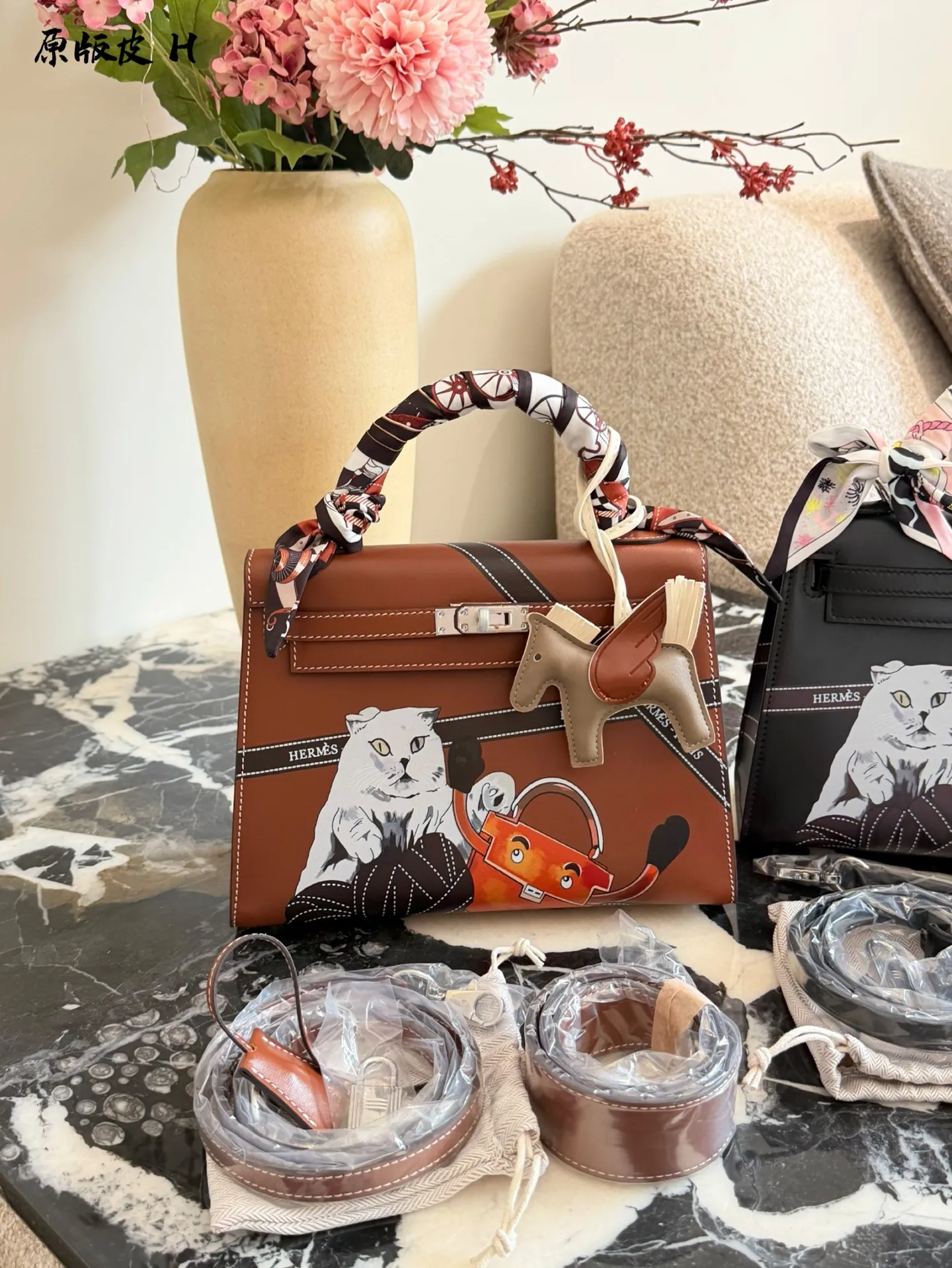 p330 爱马仕彩绘凯莉包 国这款爱马仕Kelly 25彩绘包，采用Epsom牛皮， 耐磨又有型，金扣超精致十。包身猫咪和茶壶图案超有趣，个性满分!25x18x8cm25x18x8cm,通勤出行都很适合。丝巾点缀,优雅又俏皮，搭配小飞马挂件更显趣味，是时尚与艺术的完美结合图。