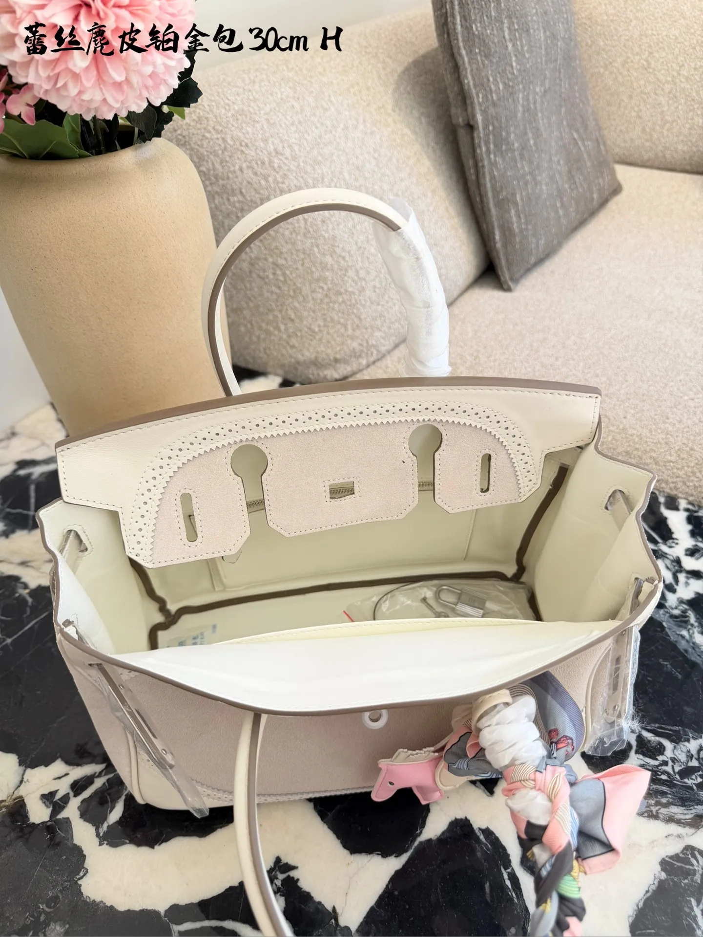 p340 Birkin30珍珠白铂金包|优雅故事的梦幻逸品 🌙 前任主人的故事 前任主人是资深爱马仕藏家,当初为了重要场合定制这只 Birkin 30,珍珠灰配白银 Swift 皮,蕾丝边装饰更添柔美。后来因个人风格转向极简,虽万分不舍,仍希望它能继续陪伴懂它的人,让这份优雅延续。 💎 设计与品质解析 ✨设计故事:Birkin 系列本就是爱马仕经典传奇,这只珍珠灰配色温柔高级,蕾丝边装饰打破常规,将法式浪漫与铂金包的大气融合,背出街就是 “行走的高奢名片”。 ✨材质与成色:采用细腻柔软的 Swift 皮,触感如丝绸般顺滑;珍珠灰配色高级不挑人,白银金属扣精致闪耀。成色近乎闲置未使用,五金无氧化,皮质无磨损,宛如全新。 ✨尺寸与实用度:30*15*21.5cm 黄金尺寸,日常通勤能装下平板、钱包、化妆品;出席晚宴、商务场合,随手拎起即刻提升气场。