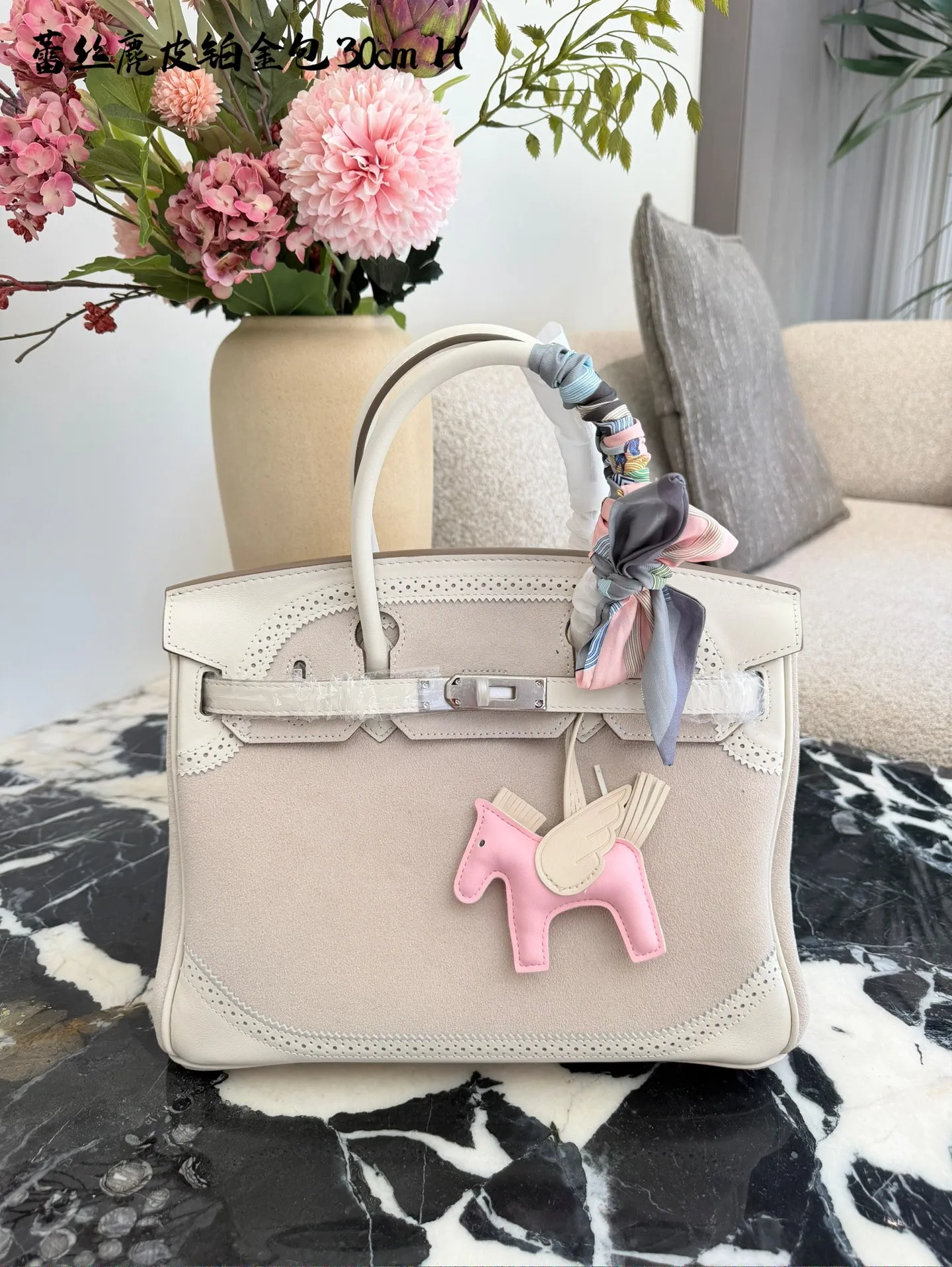 p340 Birkin30珍珠白铂金包｜优雅故事的梦幻逸品 🌙 前任主人的故事 前任主人是资深爱马仕藏家，当初为了重要场合定制这只 Birkin 30，珍珠灰配白银 Swift 皮，蕾丝边装饰更添柔美。后来因个人风格转向极简，虽万分不舍，仍希望它能继续陪伴懂它的人，让这份优雅延续。 💎 设计与品质解析 ✨设计故事：Birkin 系列本就是爱马仕经典传奇，这只珍珠灰配色温柔高级，蕾丝边装饰打破常规，将法式浪漫与铂金包的大气融合，背出街就是 &ldquo;行走的高奢名片&rdquo;。 ✨材质与成色：采用细腻柔软的 Swift 皮，触感如丝绸般顺滑；珍珠灰配色高级不挑人，白银金属扣精致闪耀。成色近乎闲置未使用，五金无氧化，皮质无磨损，宛如全新。 ✨尺寸与实用度：30*15*21.5cm 黄金尺寸，日常通勤能装下平板、钱包、化妆品；出席晚宴、商务场合，随手拎起即刻提升气场。