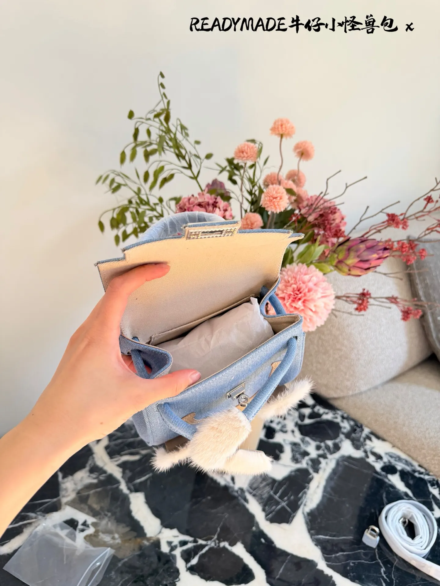 p215 READYMADE牛仔小怪兽包 国日本小众品牌READYMADE的牛仔小怪兽包,灵感来 自爱马仕Kelly Doll,浅蓝牛仔布+貂毛手脚,手感超柔软,趣味满分汁。迷你尺寸约18cm,能装手机、气垫等日常小物,手拎斜挎都OK,街头风、甜酷风都能轻松驾驭!部分配色已停产,收藏价值高,超适合喜欢个性和可爱风的姐妹们。