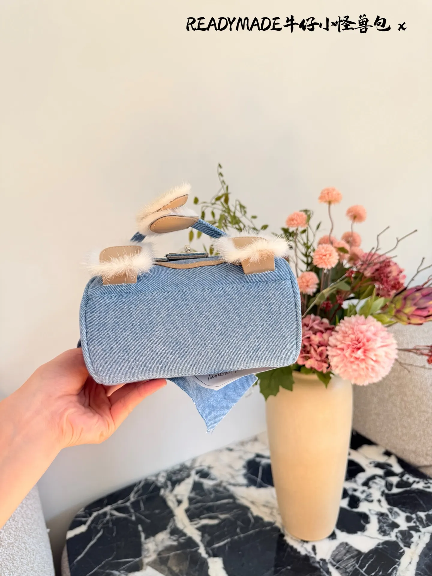 p215 READYMADE牛仔小怪兽包 国日本小众品牌READYMADE的牛仔小怪兽包,灵感来 自爱马仕Kelly Doll,浅蓝牛仔布+貂毛手脚,手感超柔软,趣味满分汁。迷你尺寸约18cm,能装手机、气垫等日常小物,手拎斜挎都OK,街头风、甜酷风都能轻松驾驭!部分配色已停产,收藏价值高,超适合喜欢个性和可爱风的姐妹们。