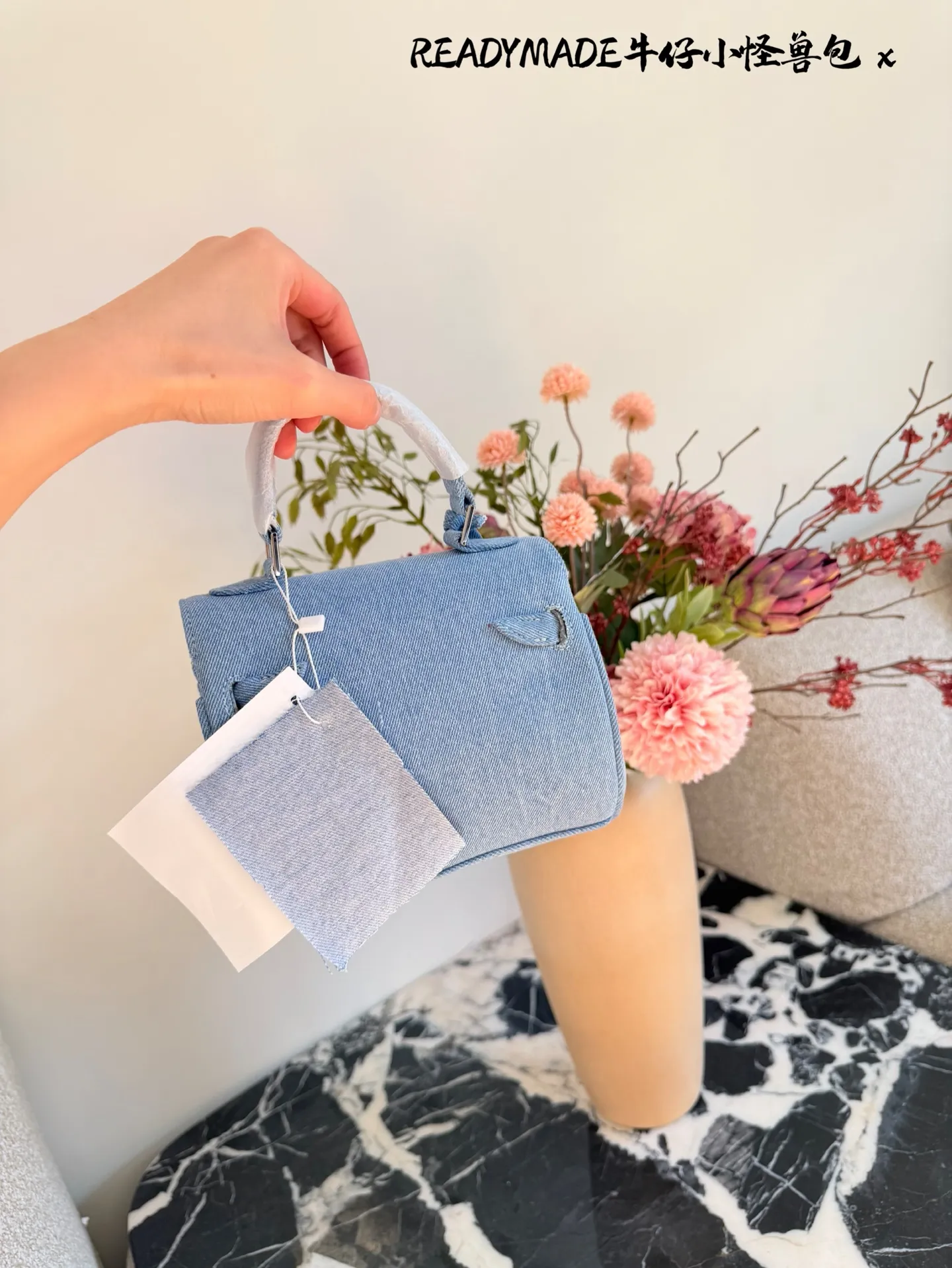p215 READYMADE牛仔小怪兽包 国日本小众品牌READYMADE的牛仔小怪兽包,灵感来 自爱马仕Kelly Doll,浅蓝牛仔布+貂毛手脚,手感超柔软,趣味满分汁。迷你尺寸约18cm,能装手机、气垫等日常小物,手拎斜挎都OK,街头风、甜酷风都能轻松驾驭!部分配色已停产,收藏价值高,超适合喜欢个性和可爱风的姐妹们。