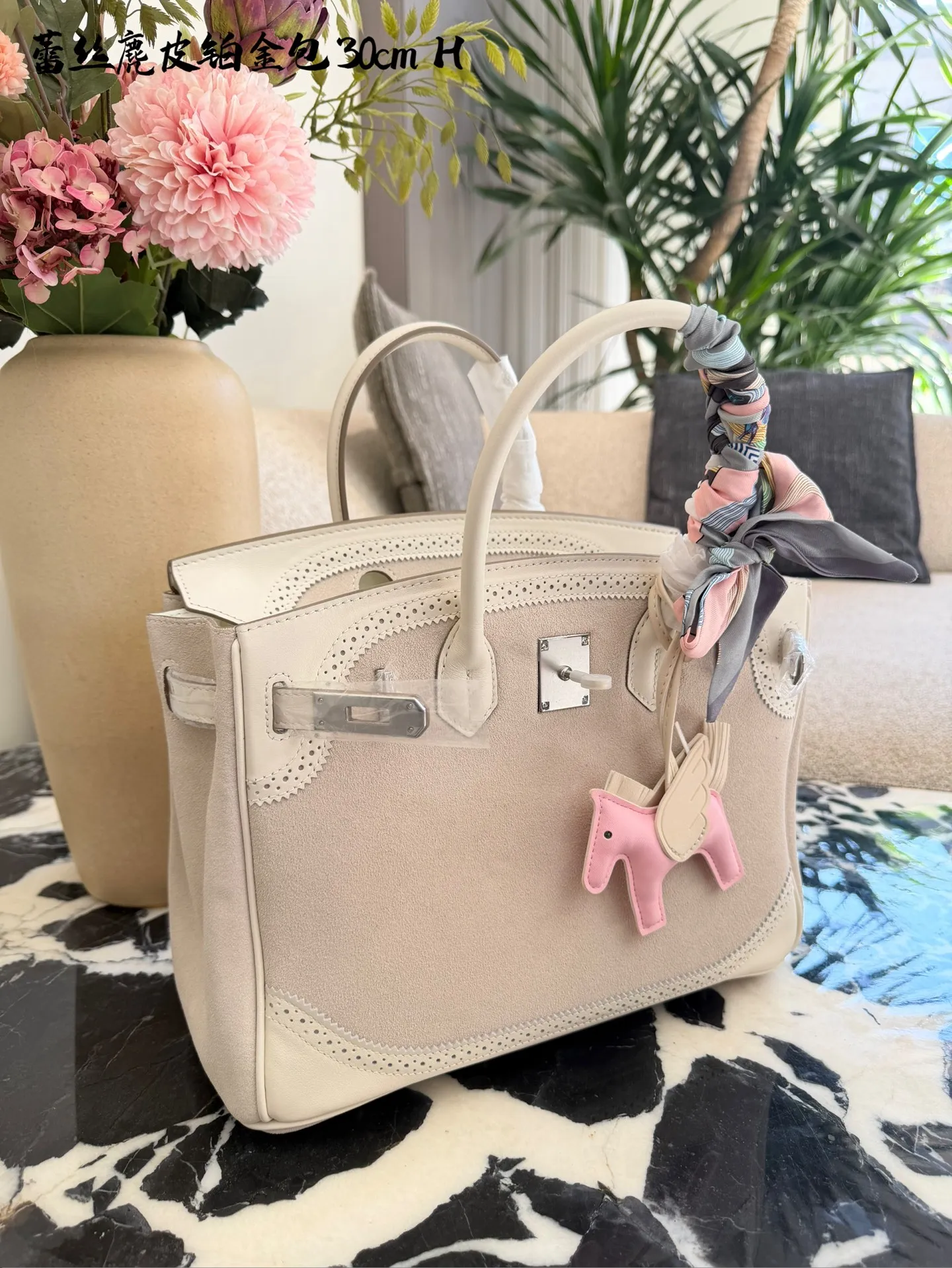 p340 Birkin30珍珠白铂金包|优雅故事的梦幻逸品 🌙 前任主人的故事 前任主人是资深爱马仕藏家,当初为了重要场合定制这只 Birkin 30,珍珠灰配白银 Swift 皮,蕾丝边装饰更添柔美。后来因个人风格转向极简,虽万分不舍,仍希望它能继续陪伴懂它的人,让这份优雅延续。 💎 设计与品质解析 ✨设计故事:Birkin 系列本就是爱马仕经典传奇,这只珍珠灰配色温柔高级,蕾丝边装饰打破常规,将法式浪漫与铂金包的大气融合,背出街就是 “行走的高奢名片”。 ✨材质与成色:采用细腻柔软的 Swift 皮,触感如丝绸般顺滑;珍珠灰配色高级不挑人,白银金属扣精致闪耀。成色近乎闲置未使用,五金无氧化,皮质无磨损,宛如全新。 ✨尺寸与实用度:30*15*21.5cm 黄金尺寸,日常通勤能装下平板、钱包、化妆品;出席晚宴、商务场合,随手拎起即刻提升气场。