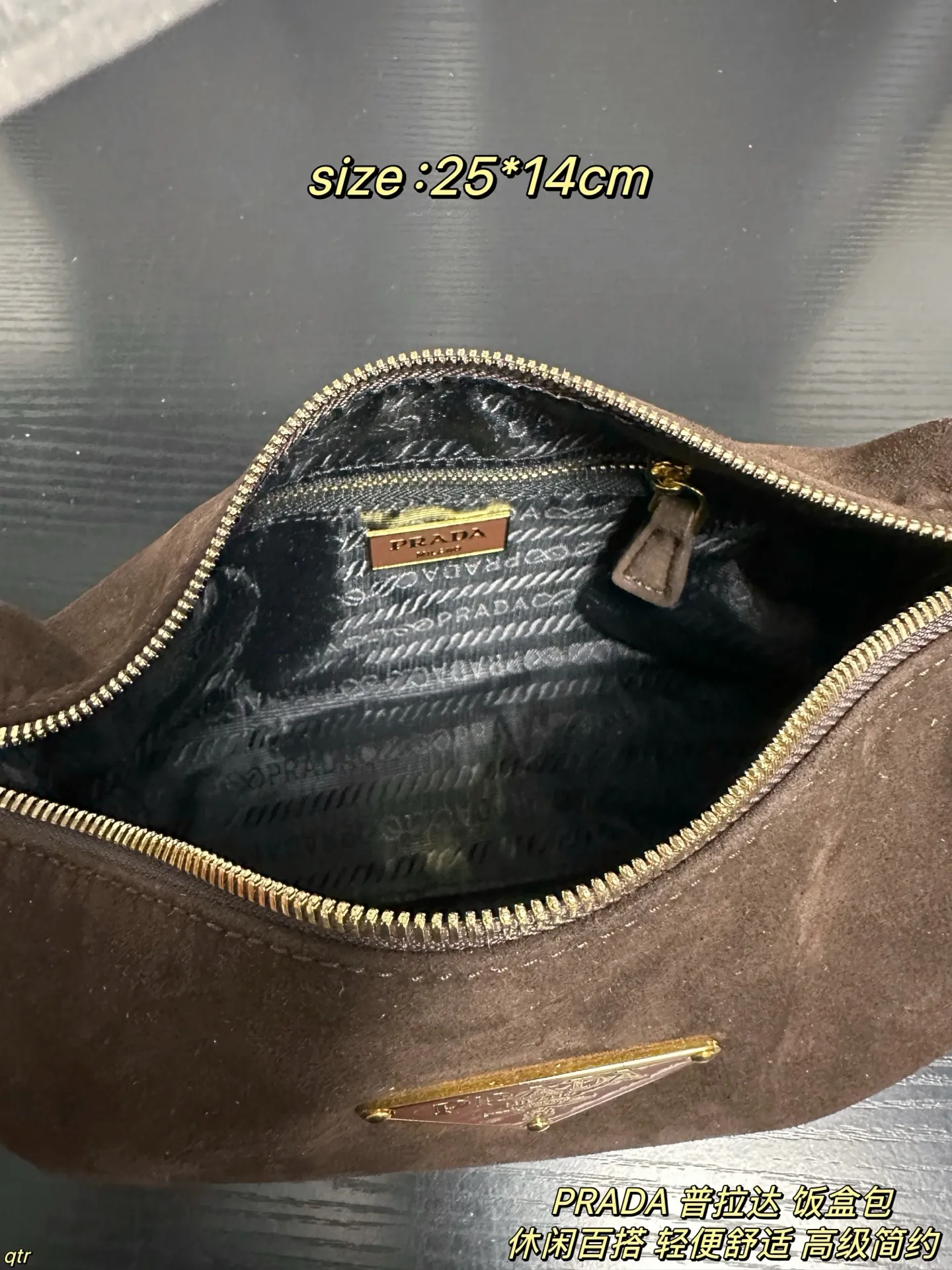P105配盒 PRADA 普拉达 饭盒包 这款包采用进口麂皮,具有柔软的轮廓和多个口袋,轻质实用的Re-Nylon强调了设计的多功能风格,而皮革细节和标志性点缀则反映了Prada的手工传统,配有2条可拆卸、可调节的编织标志带肩带,容量空间大,上身效果非常时尚。又是一款永久不过时爆款。值得拥有 尺寸:25*14cm