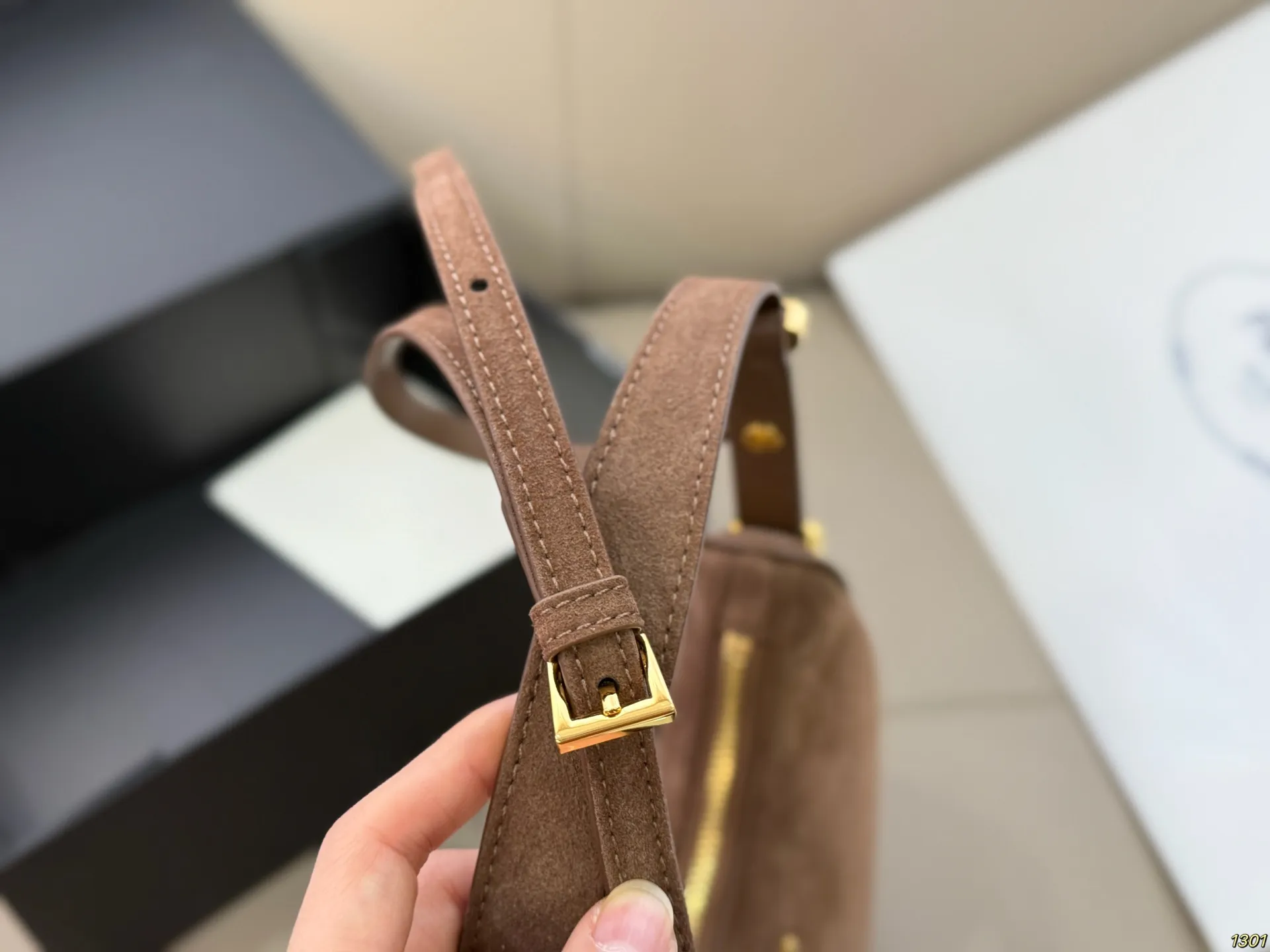 &yen;180 Prada 普拉达 Araue麂皮月牙腋下包 弧形乡设计灵感源自新月，皮革＋珐琅三角徽标，低调优雅又超有辨识度。双肩带设计，手提肩背都OK，容量适中，通勤休闲都能用。新月造型寓意新生与圆满，实用又时髦，是本季超火单品，明星博主都在背！搭配简约或复古穿搭，气质直接拉满尺寸23*13