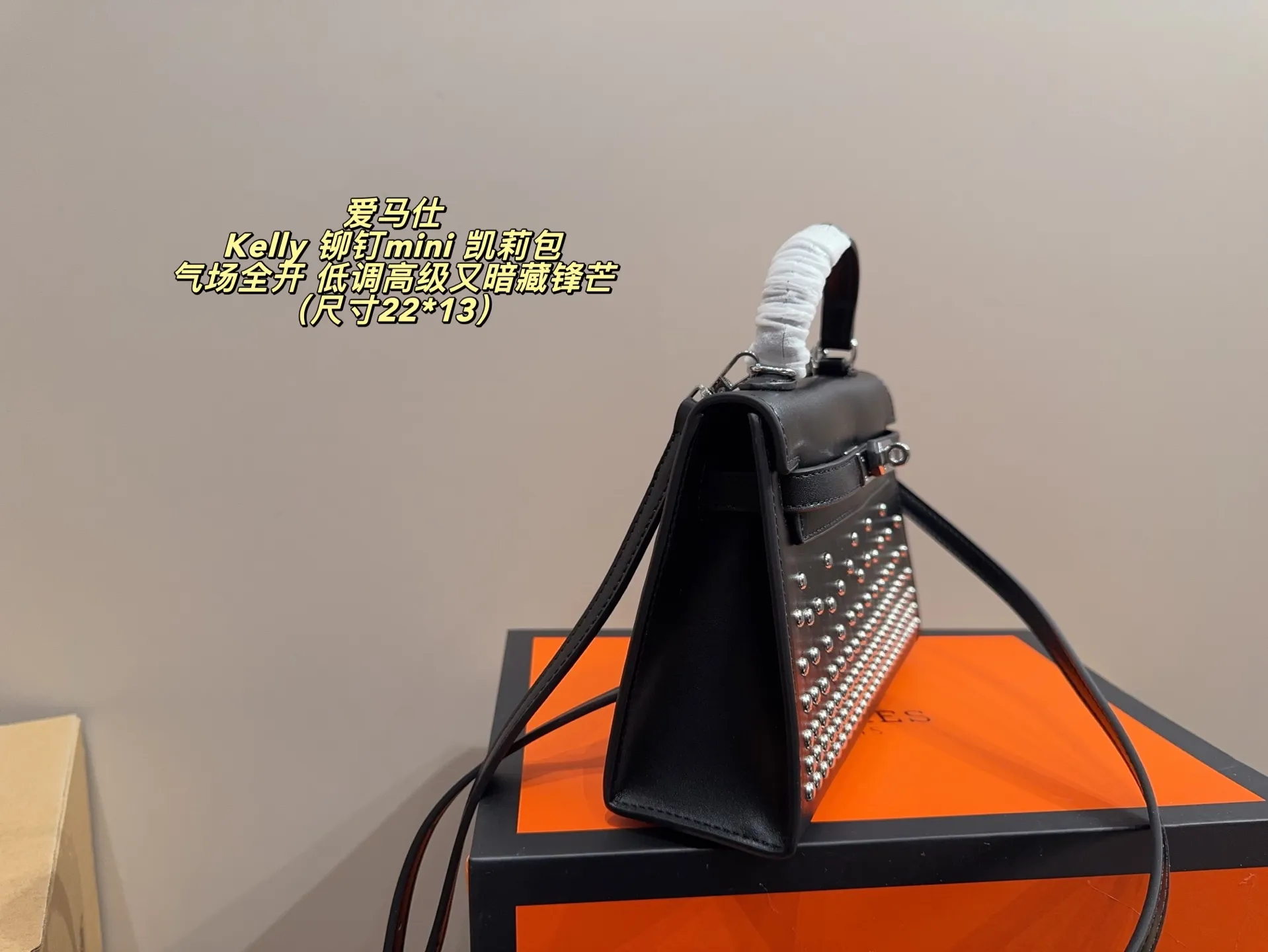 P150 无盒配布袋⚠️尺寸22*13 爱马仕 Kelly 铆钉mini 凯莉包 经典的Box小牛皮,包身加入了117颗纯手工手打钉,仔细看每颗钉子都能看出有敲打的痕迹,珠宝级打磨,每颗窝钉都圆润饱满。让整个包瞬间摇滚风拉满,再加上银扣的清冷,简直气场全开。黑银的确是更酷的配色,黑武士的既视感,低调高级又暗藏锋芒。目前黑银的热度远超黑金,金棕等经典配色。只要喜欢,就大胆拿下!