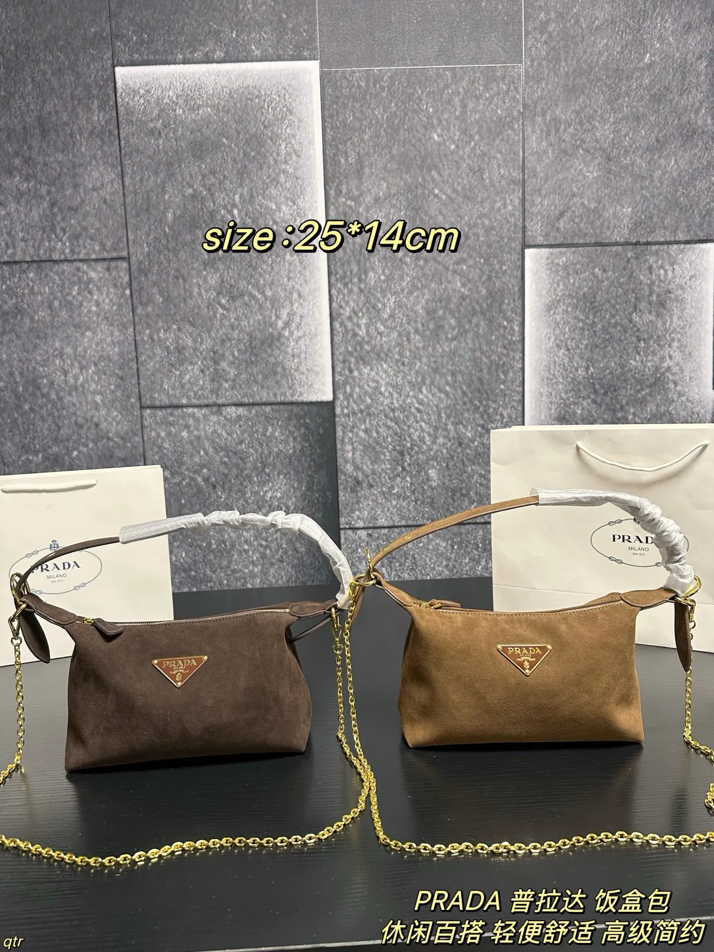 P105配盒 PRADA 普拉达 饭盒包 这款包采用进口麂皮,具有柔软的轮廓和多个口袋,轻质实用的Re-Nylon强调了设计的多功能风格,而皮革细节和标志性点缀则反映了Prada的手工传统,配有2条可拆卸、可调节的编织标志带肩带,容量空间大,上身效果非常时尚。又是一款永久不过时爆款。值得拥有 尺寸:25*14cm