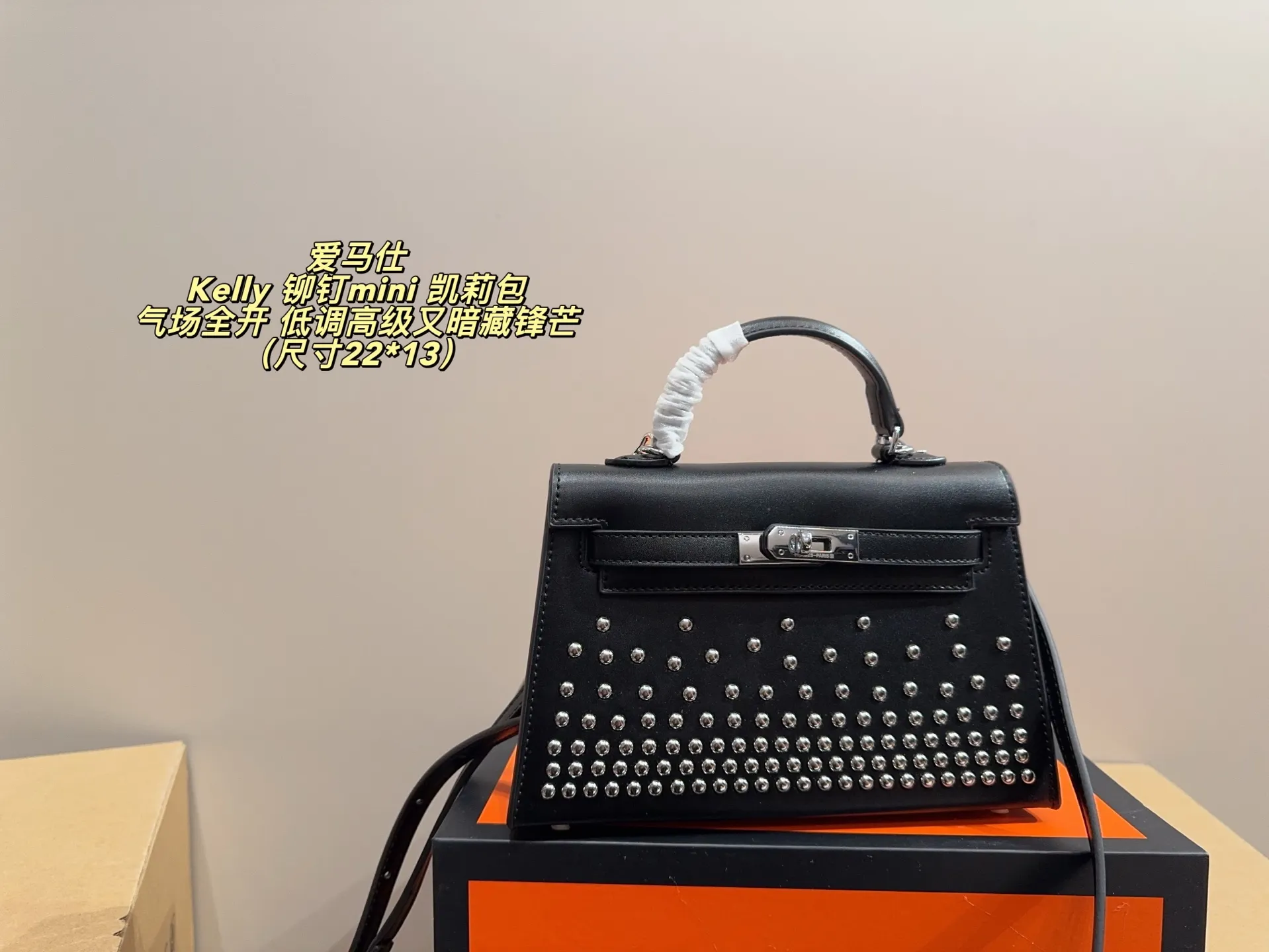 P150 无盒配布袋⚠️尺寸22*13 爱马仕 Kelly 铆钉mini 凯莉包 经典的Box小牛皮,包身加入了117颗纯手工手打钉,仔细看每颗钉子都能看出有敲打的痕迹,珠宝级打磨,每颗窝钉都圆润饱满。让整个包瞬间摇滚风拉满,再加上银扣的清冷,简直气场全开。黑银的确是更酷的配色,黑武士的既视感,低调高级又暗藏锋芒。目前黑银的热度远超黑金,金棕等经典配色。只要喜欢,就大胆拿下!