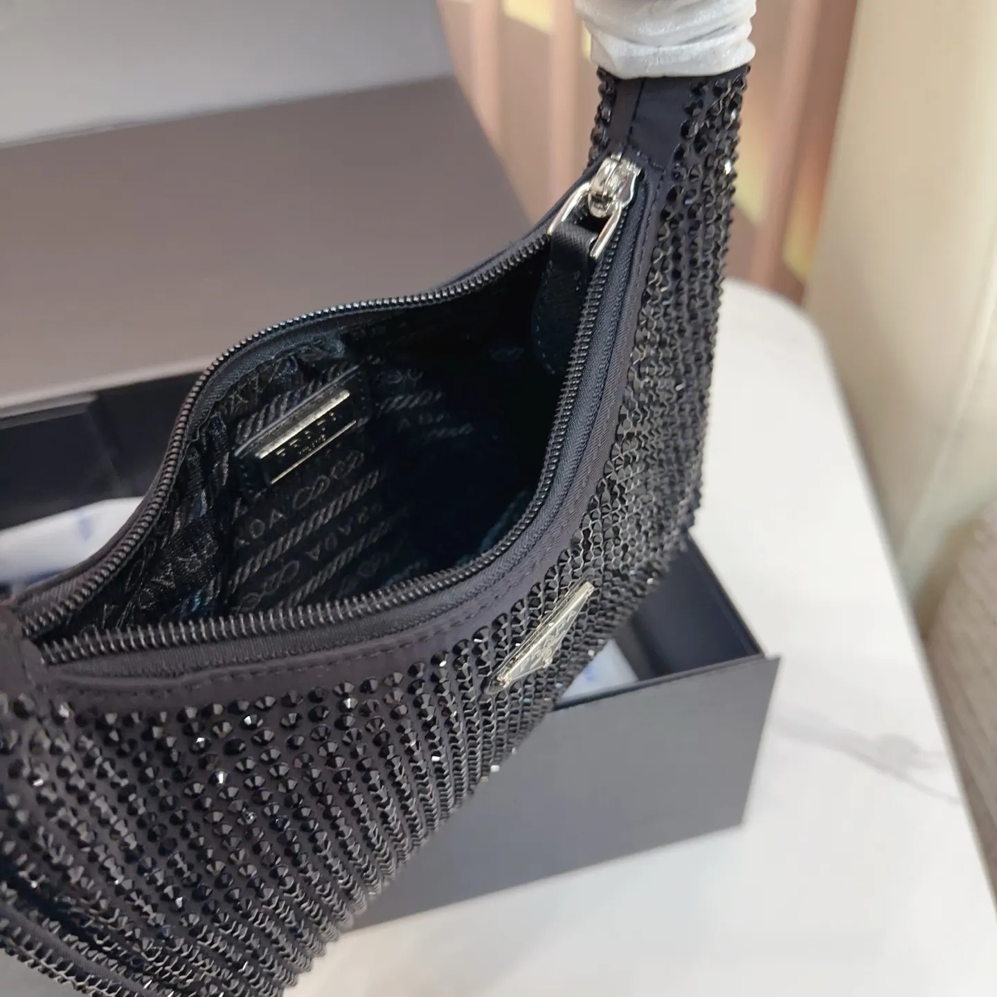 P120 礼盒🎁 size:21×12 PRADA 普拉达水钻Re-Edition hobo腋下包💕 包包焕以轻盈的绸缎面料制作, 通体镶嵌璀璨的水钻为亮点, 搭配珐琅三角包扣,容量🉑️~ 任何场合都能成为引人注目的焦点✨yx