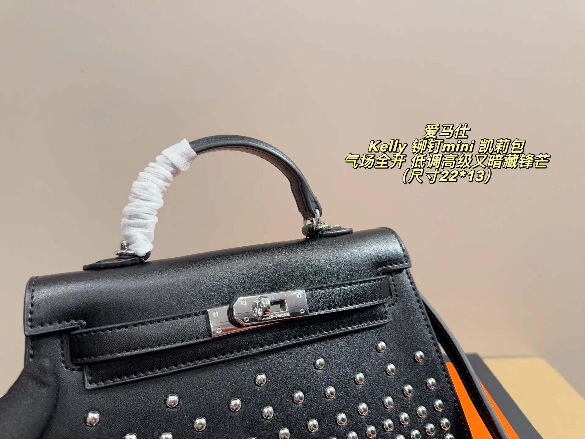 P150 无盒配布袋⚠️尺寸22*13 爱马仕 Kelly 铆钉mini 凯莉包 经典的Box小牛皮，包身加入了117颗纯手工手打钉，仔细看每颗钉子都能看出有敲打的痕迹，珠宝级打磨，每颗窝钉都圆润饱满。让整个包瞬间摇滚风拉满，再加上银扣的清冷，简直气场全开。黑银的确是更酷的配色，黑武士的既视感，低调高级又暗藏锋芒。目前黑银的热度远超黑金，金棕等经典配色。只要喜欢，就大胆拿下！