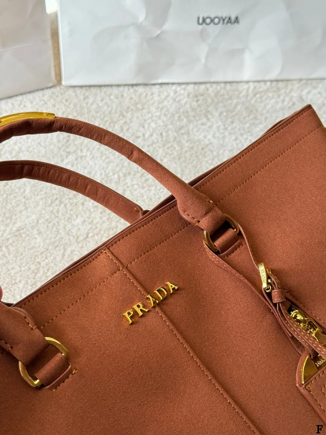 p190 Prada链条托特包 Prada这款棕色链条托特包，采用优质牛皮，手感细腻耐用。金属链条+皮革肩带，手提斜挎都OK，超百搭！正面Logo低调有辦识度，内部空间超大，通勤or短途旅行都能装下日常用品。拉链口袋设计，收纳更方便，实用又时髦，是都市女生的热门选择！ 尺寸 35 33cm