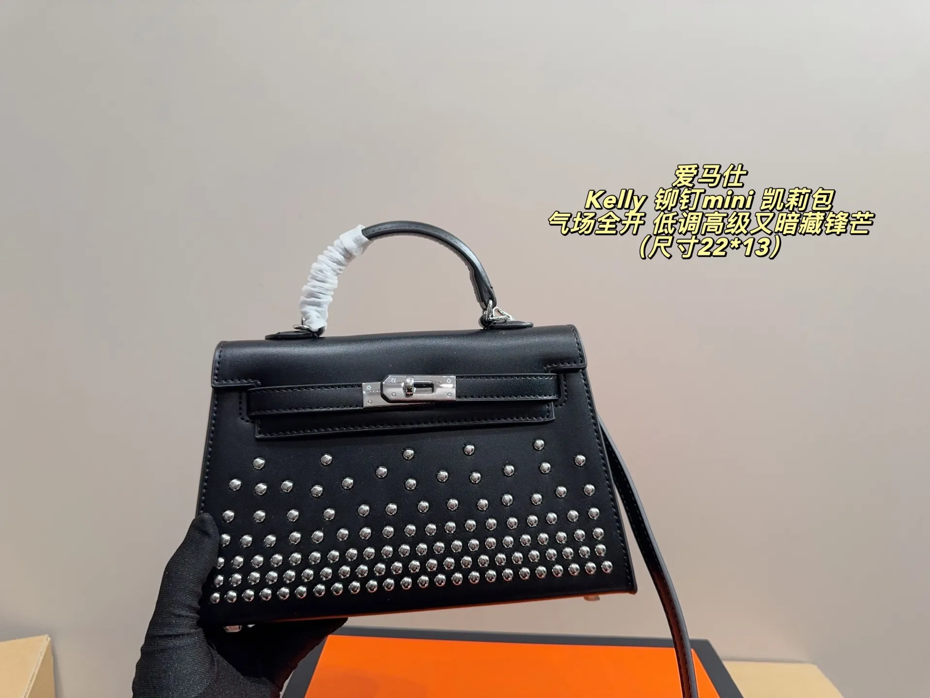 P150 无盒配布袋⚠️尺寸22*13 爱马仕 Kelly 铆钉mini 凯莉包 经典的Box小牛皮,包身加入了117颗纯手工手打钉,仔细看每颗钉子都能看出有敲打的痕迹,珠宝级打磨,每颗窝钉都圆润饱满。让整个包瞬间摇滚风拉满,再加上银扣的清冷,简直气场全开。黑银的确是更酷的配色,黑武士的既视感,低调高级又暗藏锋芒。目前黑银的热度远超黑金,金棕等经典配色。只要喜欢,就大胆拿下!