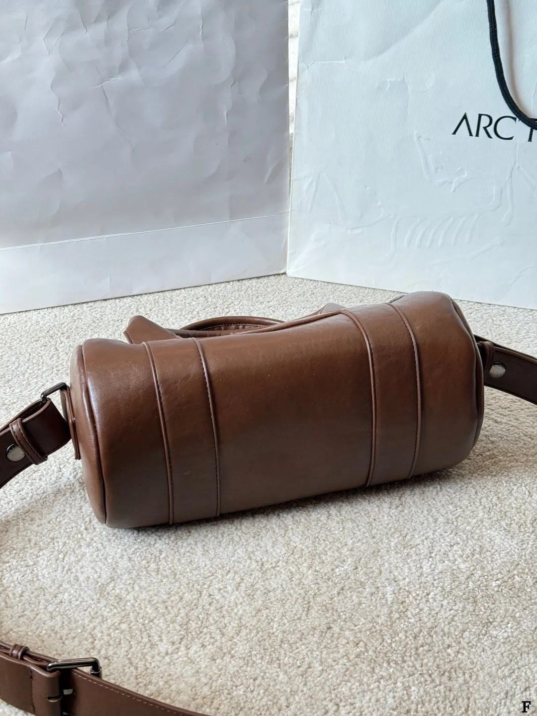 p170 Prada 26SS圆筒包 些Prada 26SS圆筒包是春夏系列新品,棕色皮革质感细腻耐用,简约复古风格超有范!圆筒造型+双提手+可拆卸肩带,手提斜挎都OK,通勤休闲都能搭。正面Logo低调有辨识度,金属环扣点缀细节满分。日本快闪首发,稀缺属性,时尚实用,Prada粉丝必入! 尺寸 30 15cm