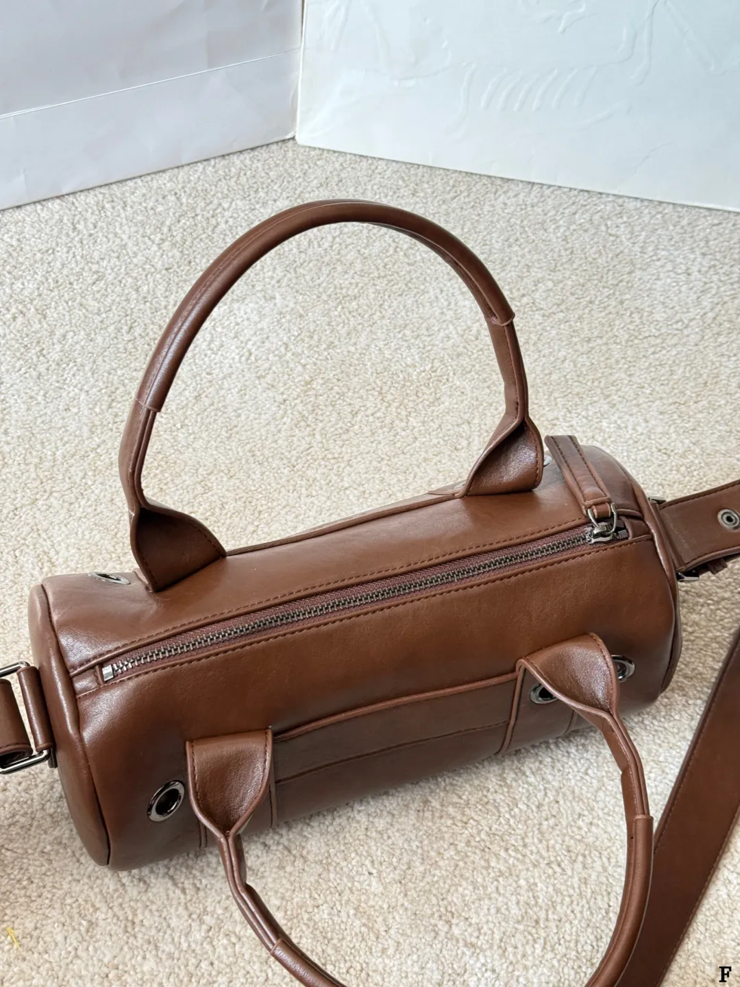 p170 Prada 26SS圆筒包 些Prada 26SS圆筒包是春夏系列新品，棕色皮革质感细腻耐用，简约复古风格超有范！圆筒造型+双提手+可拆卸肩带，手提斜挎都OK，通勤休闲都能搭。正面Logo低调有辨识度，金属环扣点缀细节满分。日本快闪首发，稀缺属性，时尚实用，Prada粉丝必入！ 尺寸 30 15cm