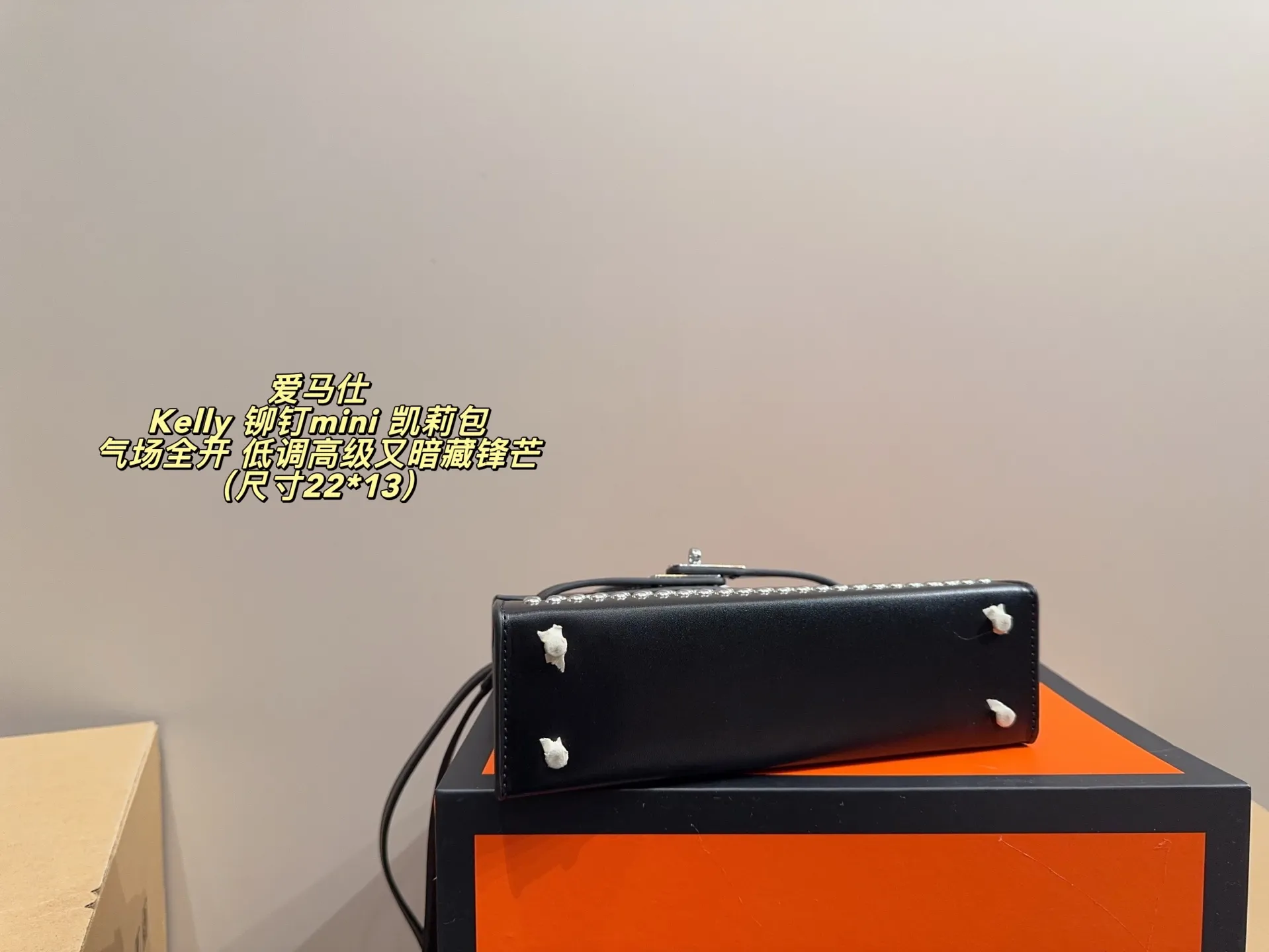 P150 无盒配布袋⚠️尺寸22*13 爱马仕 Kelly 铆钉mini 凯莉包 经典的Box小牛皮,包身加入了117颗纯手工手打钉,仔细看每颗钉子都能看出有敲打的痕迹,珠宝级打磨,每颗窝钉都圆润饱满。让整个包瞬间摇滚风拉满,再加上银扣的清冷,简直气场全开。黑银的确是更酷的配色,黑武士的既视感,低调高级又暗藏锋芒。目前黑银的热度远超黑金,金棕等经典配色。只要喜欢,就大胆拿下!