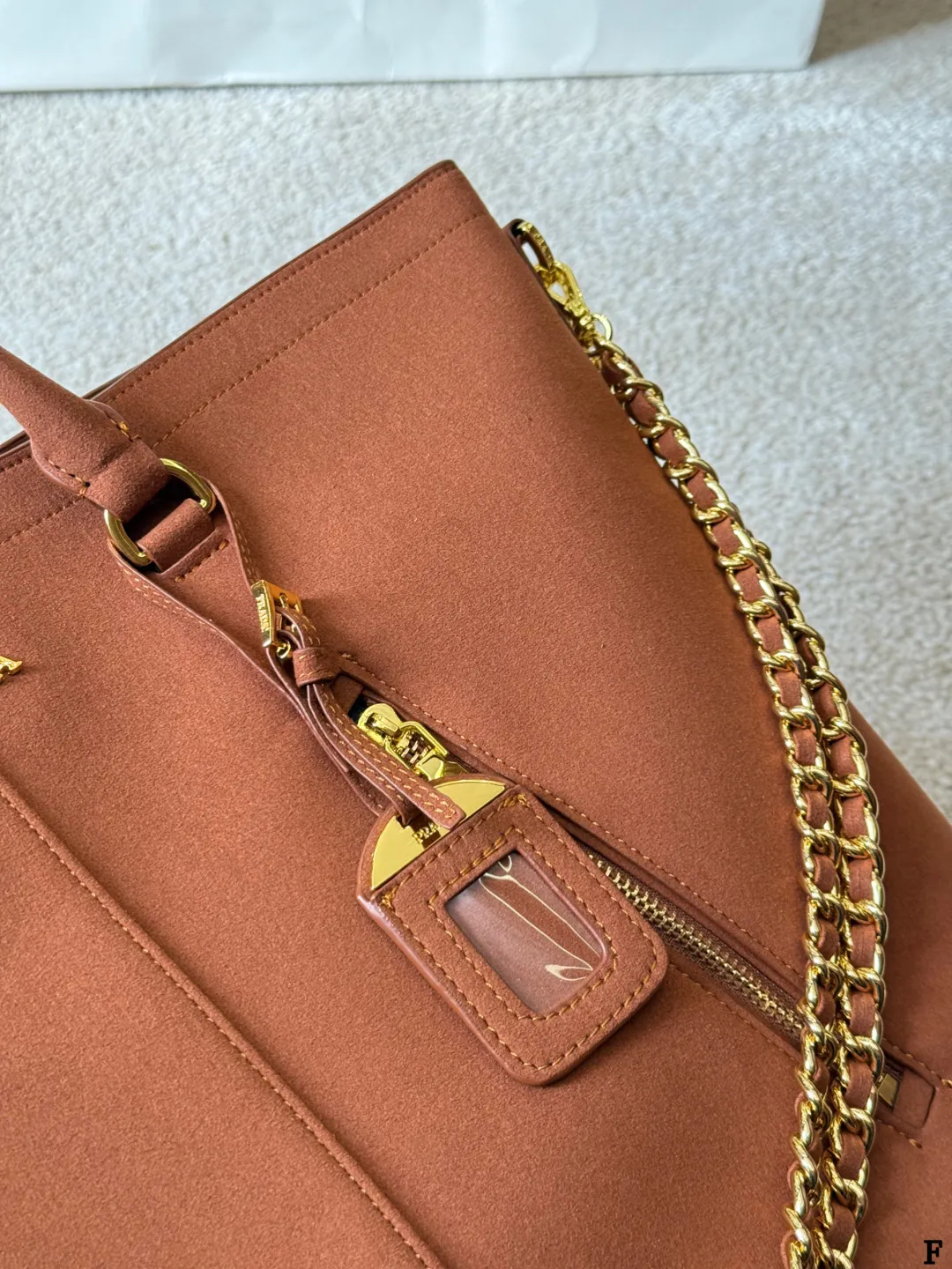 p190 Prada链条托特包 Prada这款棕色链条托特包,采用优质牛皮,手感细腻耐用。金属链条+皮革肩带,手提斜挎都OK,超百搭!正面Logo低调有辦识度,内部空间超大,通勤or短途旅行都能装下日常用品。拉链口袋设计,收纳更方便,实用又时髦,是都市女生的热门选择! 尺寸 35 33cm