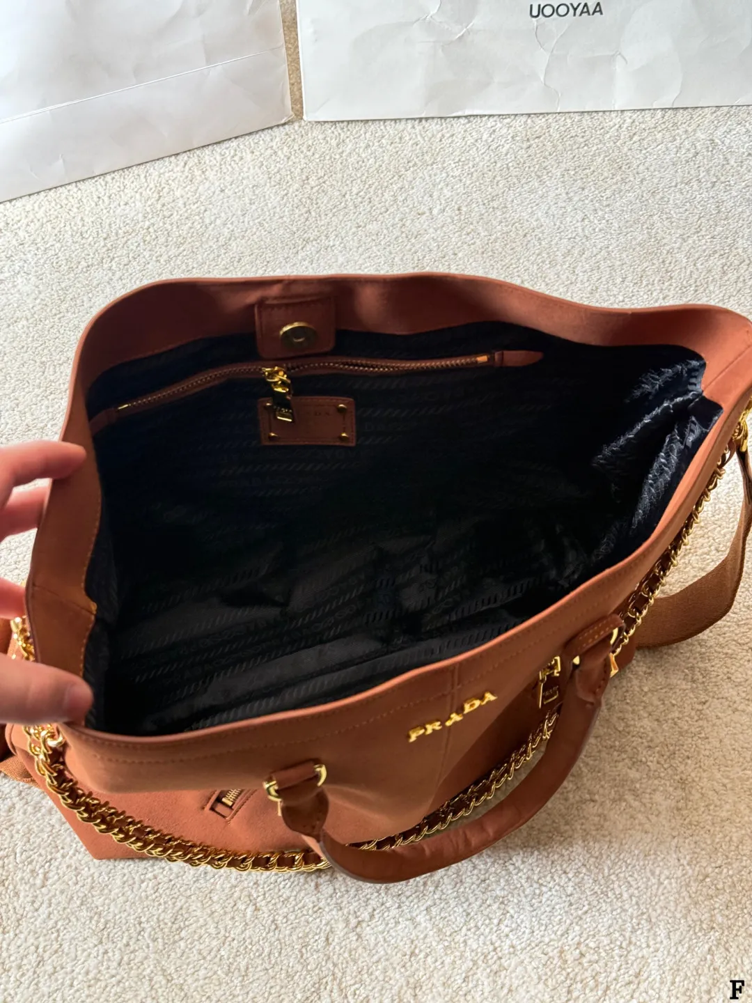 p190 Prada链条托特包 Prada这款棕色链条托特包,采用优质牛皮,手感细腻耐用。金属链条+皮革肩带,手提斜挎都OK,超百搭!正面Logo低调有辦识度,内部空间超大,通勤or短途旅行都能装下日常用品。拉链口袋设计,收纳更方便,实用又时髦,是都市女生的热门选择! 尺寸 35 33cm