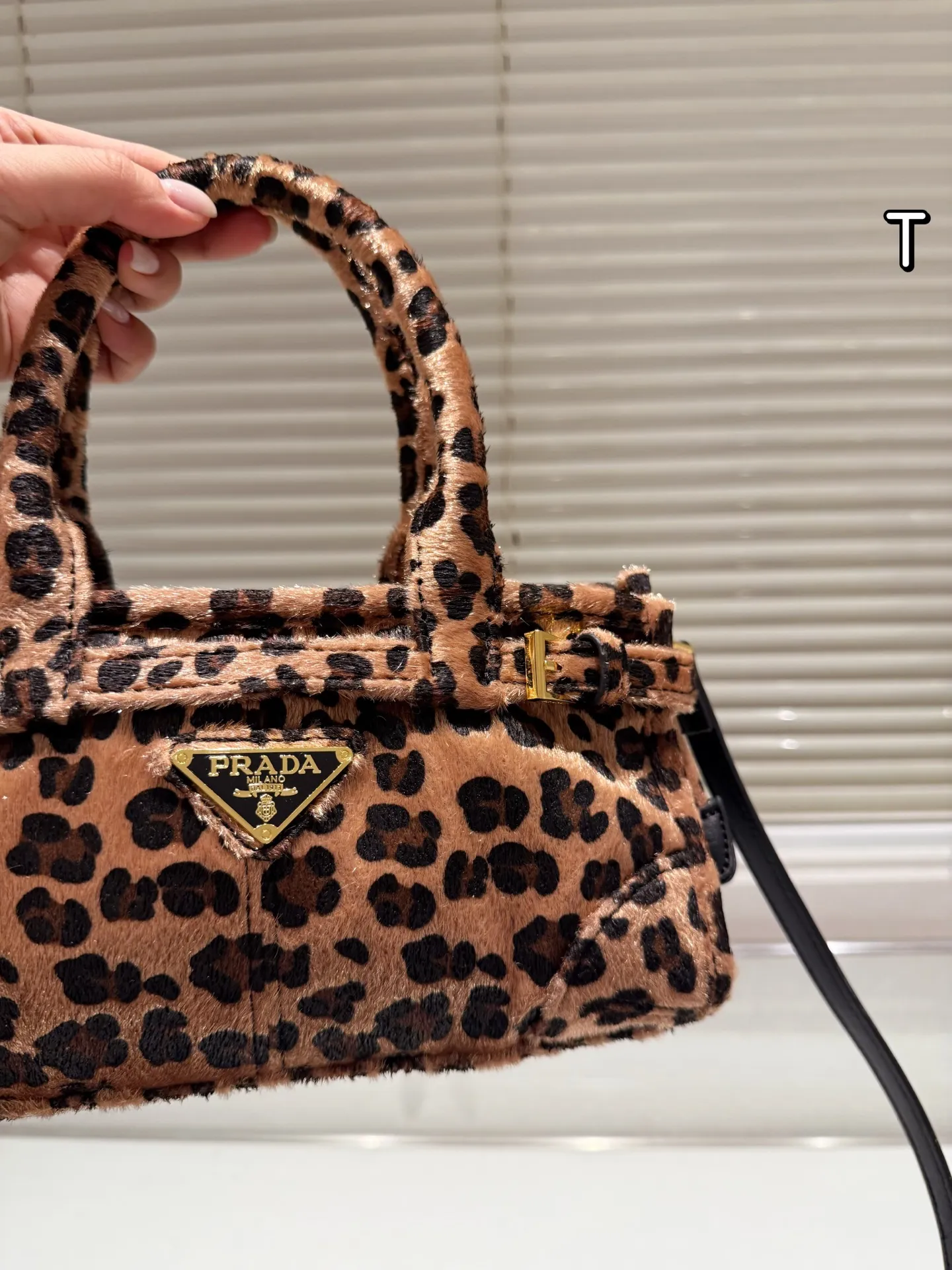 P160 Prada 普拉达Bonnie手袋 &Prada Bonnie手袋采用黑白奶牛纹压花小羊皮，触感柔软细腻，搭配标志性三角金属徽标，辨识度超高。，轻巧便携，配有可拆卸链条肩带，支持手提、单肩或斜挎多种背法。奶牛纹设计俏皮又时髦，秋冬搭配简约或亮色服饰都超出彩国，轻松提升造型亮点！ 迷你尺寸12&times;23.5x9cm