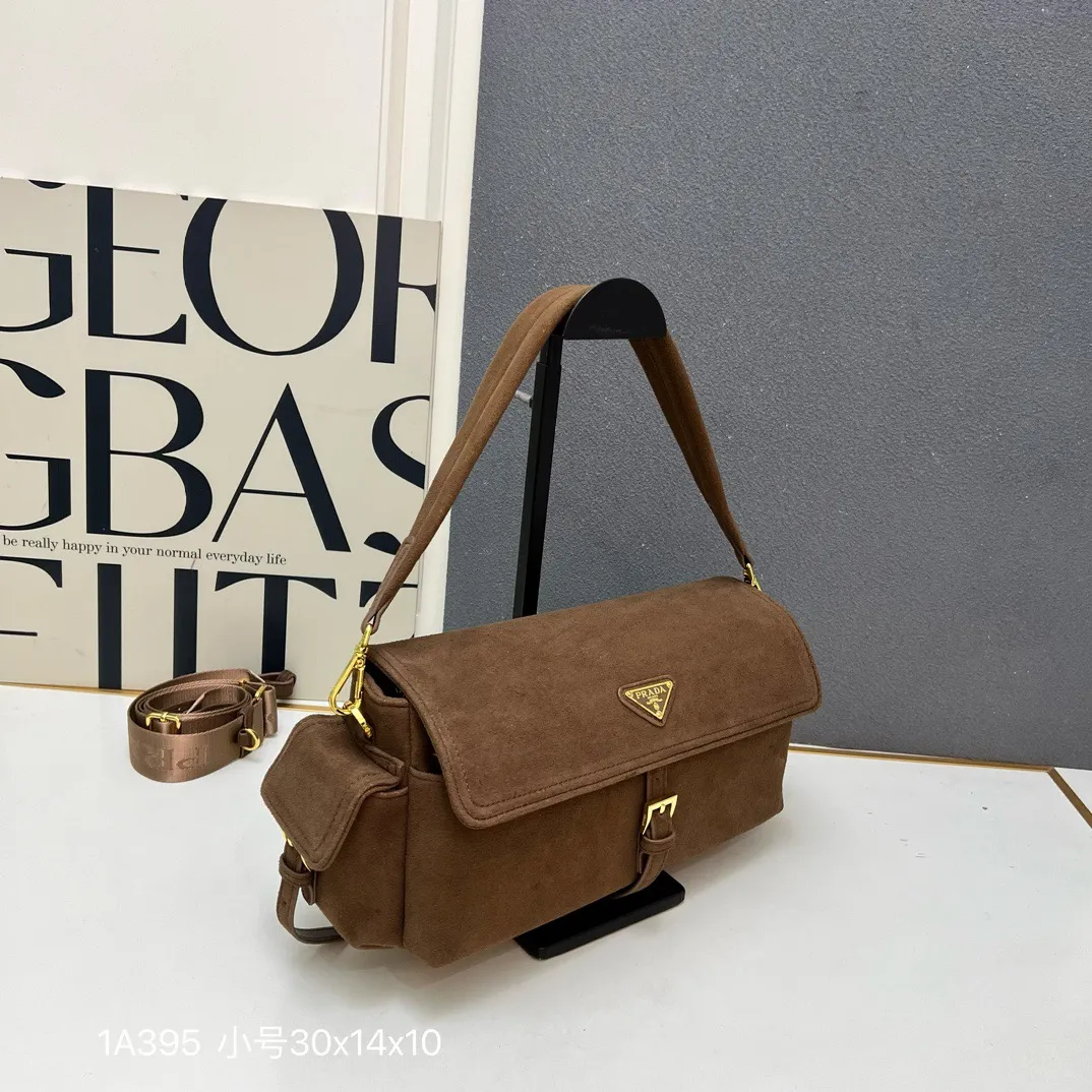 💰240包邮❗ 新款邮差包🎉1A395全皮🎉 这款手袋完美融合精致与功能性，采用再生尼龙材质，轮廓柔和，配有多个口袋。轻盈实用的设计结合运动与百搭元素，饰有涂珐琅三角形金属徽标，搭配皮革细节。配有2条肩带可拆卸，容量大，太完美，又是一款永久不过时爆款，大号男女共用，赶紧入手吧 小号:长30x高14x底10cm