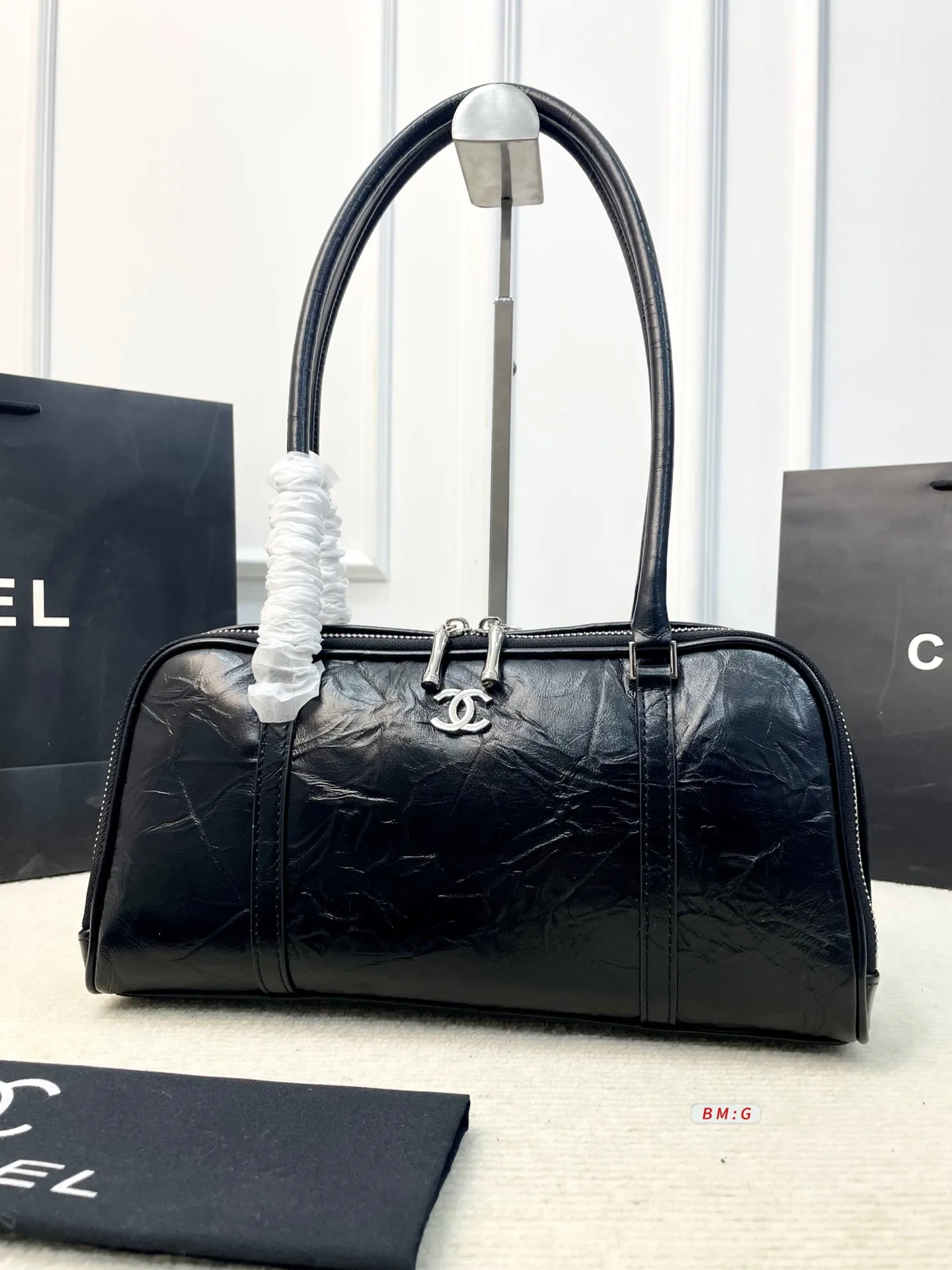 💰225 香奈儿黑色油蜡皮保龄球包，经典弧形设计，油蜡皮自带褶皱纹理，复古又高级✨。正面金属双C Logo超有辨识度，拉链开合更安全。内部空间合理，通勤休闲都能装。手柄弧形，手提肩背都OK，实用又时髦。 尺寸：31*9*16.5