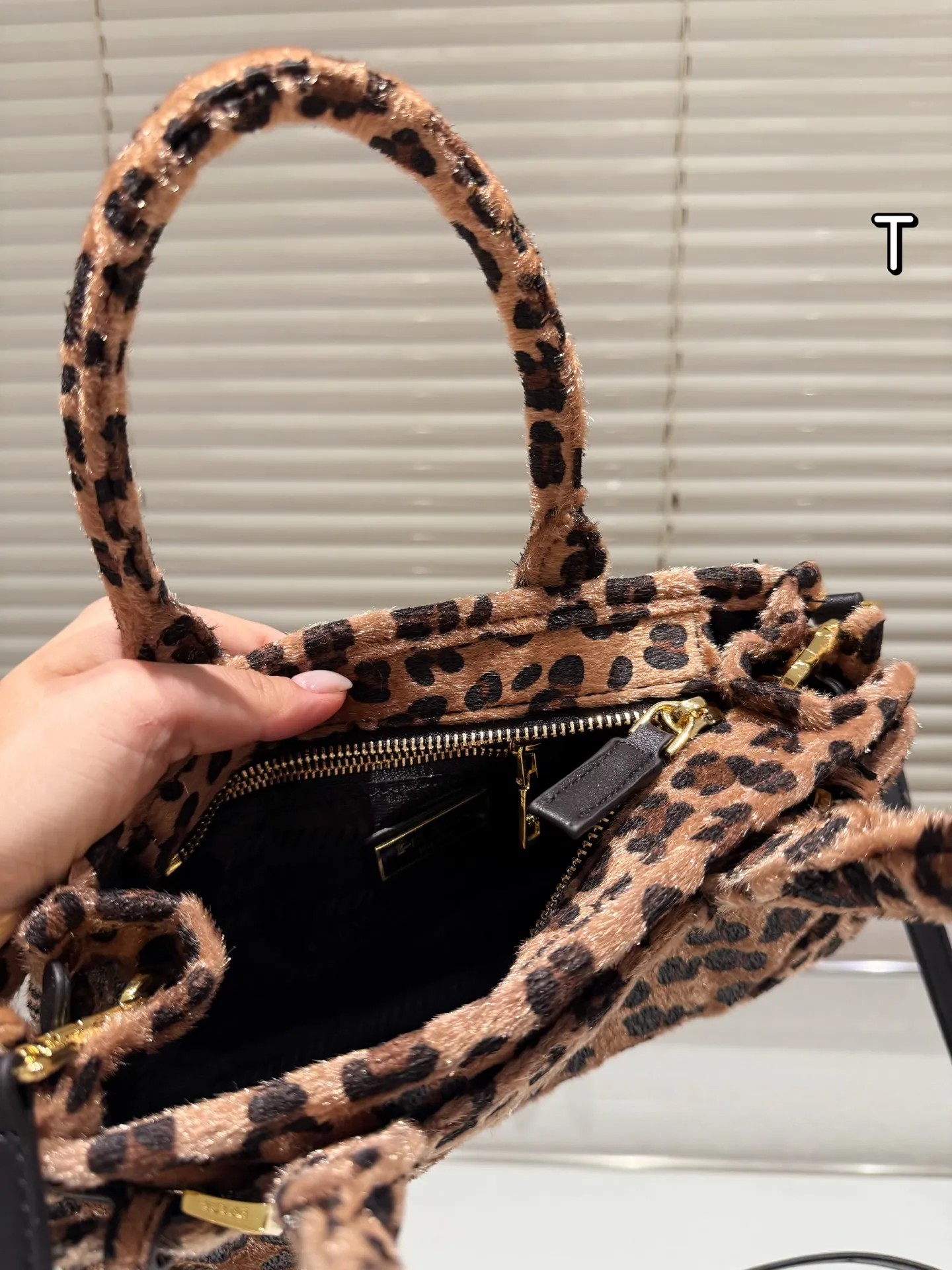 P160 Prada 普拉达Bonnie手袋 &Prada Bonnie手袋采用黑白奶牛纹压花小羊皮,触感柔软细腻,搭配标志性三角金属徽标,辨识度超高。,轻巧便携,配有可拆卸链条肩带,支持手提、单肩或斜挎多种背法。奶牛纹设计俏皮又时髦,秋冬搭配简约或亮色服饰都超出彩国,轻松提升造型亮点! 迷你尺寸12×23.5x9cm