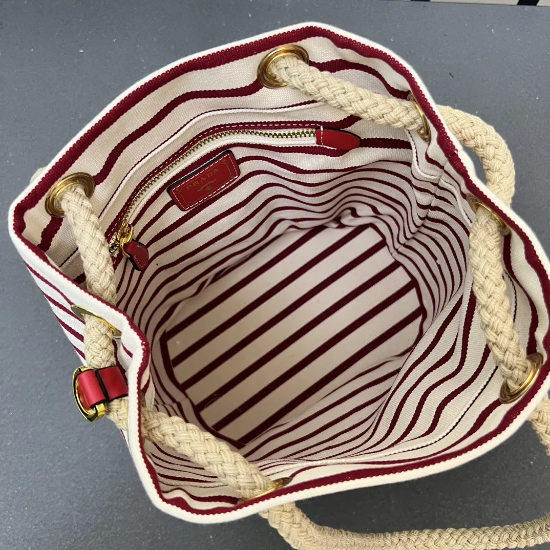 💰210包邮‼️ 🎉新款水桶包🎉1A082走秀款 这款Re-Nylon 手袋的設計采用尼龙面料和小牛皮。獨特的組合添上迷人點綴。滑動式繩索手挽凸顯這款手袋的靈活百搭,方便手提或肩背/斜跨,顶级五金。容量空间大,非常休闲时尚,又是一款永久不过时爆款,宝宝们,赶紧入手吧🎉🎉 长23.5x高28x底16.5cm