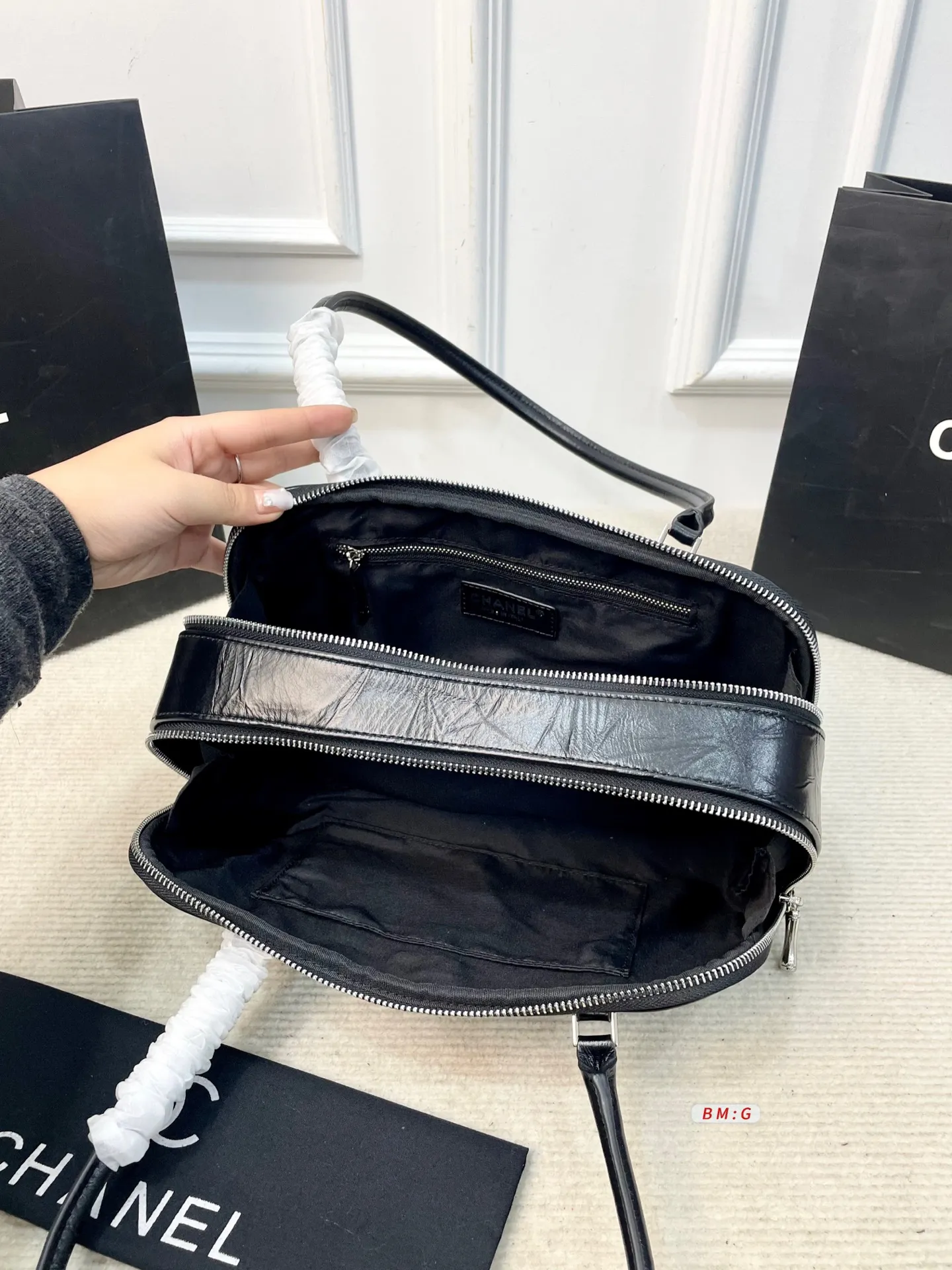 💰225 香奈儿黑色油蜡皮保龄球包，经典弧形设计，油蜡皮自带褶皱纹理，复古又高级✨。正面金属双C Logo超有辨识度，拉链开合更安全。内部空间合理，通勤休闲都能装。手柄弧形，手提肩背都OK，实用又时髦。 尺寸：31*9*16.5
