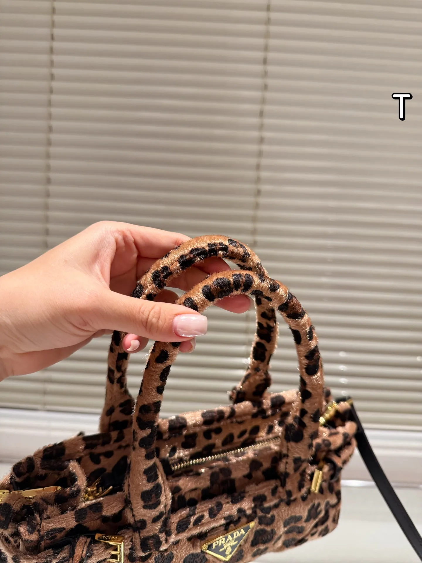 P160 Prada 普拉达Bonnie手袋 &Prada Bonnie手袋采用黑白奶牛纹压花小羊皮,触感柔软细腻,搭配标志性三角金属徽标,辨识度超高。,轻巧便携,配有可拆卸链条肩带,支持手提、单肩或斜挎多种背法。奶牛纹设计俏皮又时髦,秋冬搭配简约或亮色服饰都超出彩国,轻松提升造型亮点! 迷你尺寸12×23.5x9cm