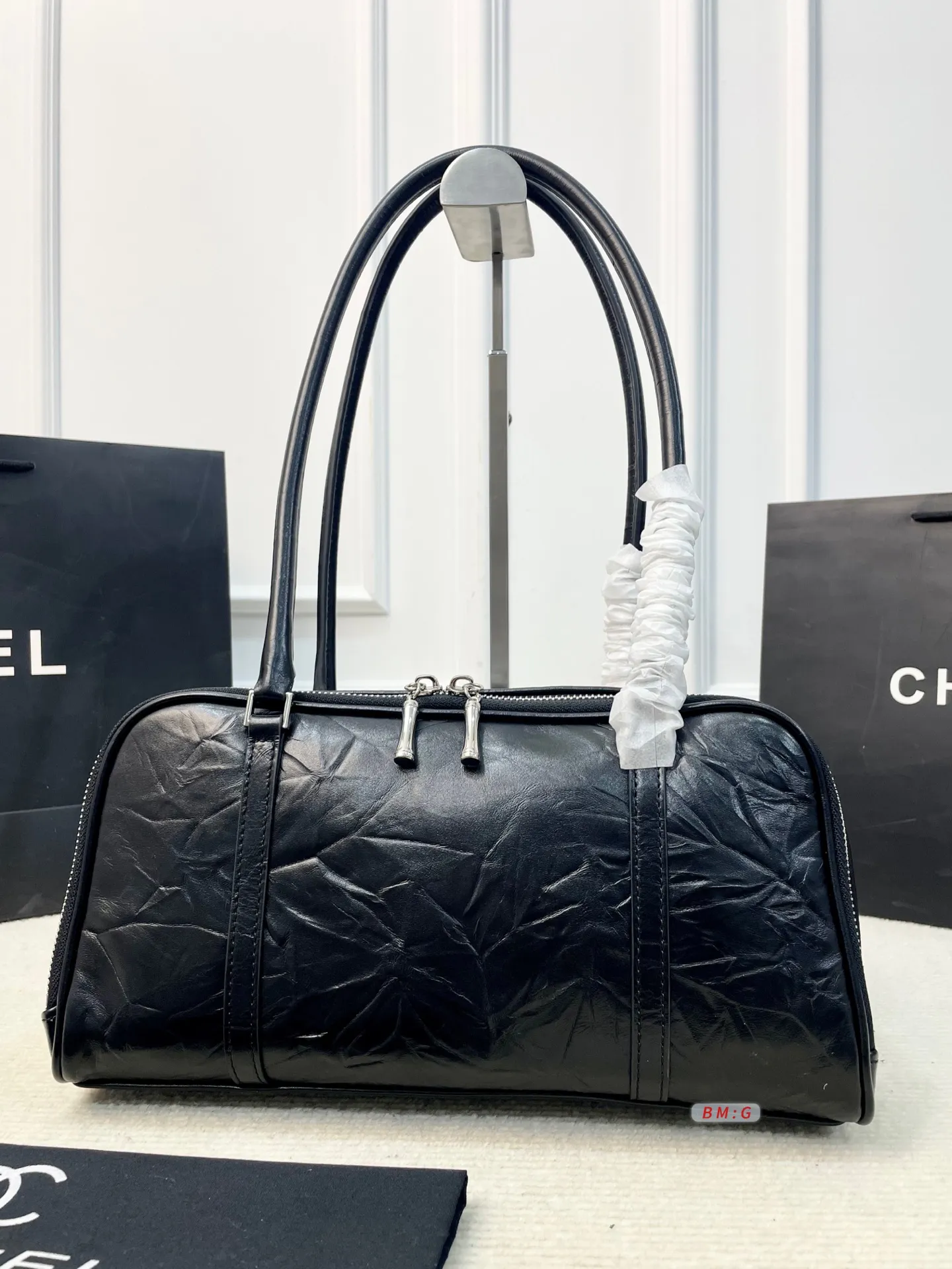 💰225 香奈儿黑色油蜡皮保龄球包，经典弧形设计，油蜡皮自带褶皱纹理，复古又高级✨。正面金属双C Logo超有辨识度，拉链开合更安全。内部空间合理，通勤休闲都能装。手柄弧形，手提肩背都OK，实用又时髦。 尺寸：31*9*16.5