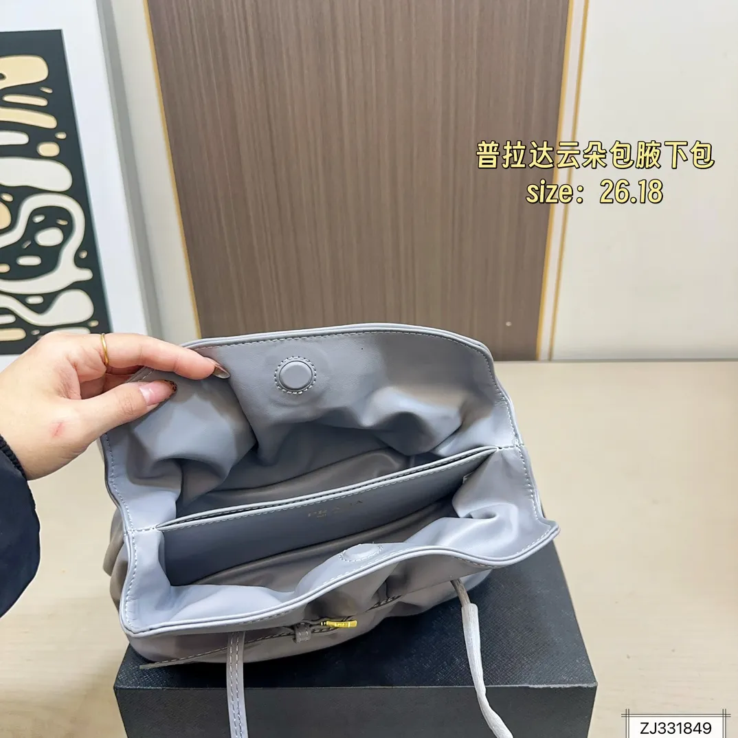 💰165 折叠盒 尺寸26&times;18 Prada 普拉达 Dada腋下包 因蓬松柔软的外形被称为&ldquo;云朵包&rdquo;，触感细腻。细长饰带束出自然褶皱，展现松弛高级的&ldquo;Raw Glamour&rdquo;风格。磁吸扣设计，容量可观，适合通勤或约会，轻松搭配各种穿搭，时髦又实用