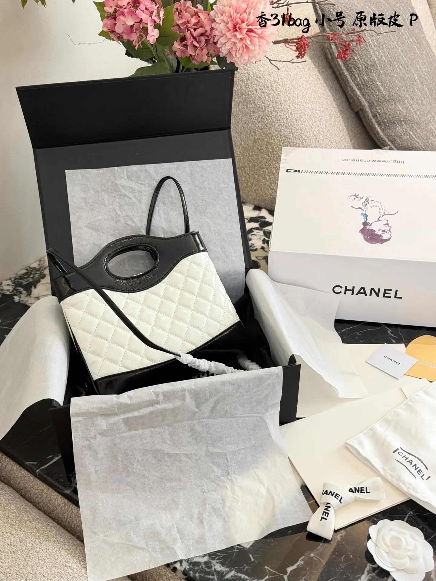 p200 香奈儿Mini31Bag熊猫色 牛皮 Q3香奈儿Mini 31 Bag熊猫色,黑白拼接超经典,漆皮+菱格纹设计,淡金色五金超有质感十。22x23x5.5cm 22x23x5.5cm,小巧精致,手提or斜挎都OK,链条肩带多种背法随心切换!旋钮扣设计更安全,容量虽小但手机钥匙都能装下,通勤出行都很适合。复古时髦,百搭不挑人,是香奈儿热门爆款之一!