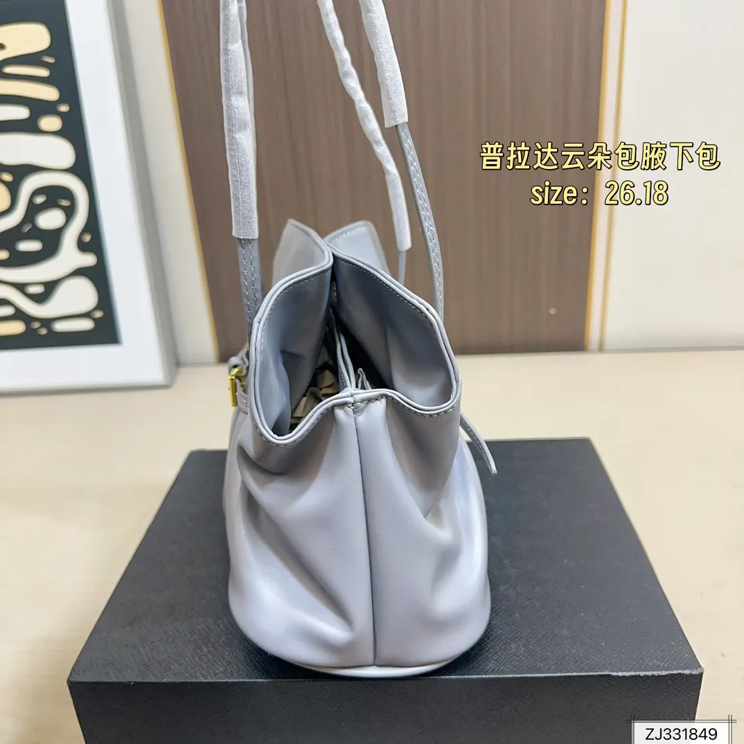 💰165 折叠盒 尺寸26&times;18 Prada 普拉达 Dada腋下包 因蓬松柔软的外形被称为&ldquo;云朵包&rdquo;，触感细腻。细长饰带束出自然褶皱，展现松弛高级的&ldquo;Raw Glamour&rdquo;风格。磁吸扣设计，容量可观，适合通勤或约会，轻松搭配各种穿搭，时髦又实用