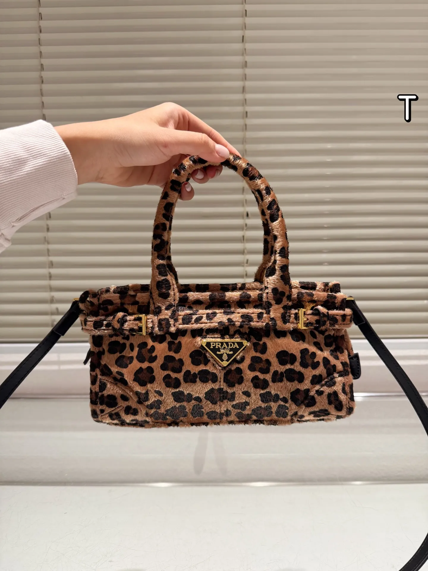 P160 Prada 普拉达Bonnie手袋 &Prada Bonnie手袋采用黑白奶牛纹压花小羊皮,触感柔软细腻,搭配标志性三角金属徽标,辨识度超高。,轻巧便携,配有可拆卸链条肩带,支持手提、单肩或斜挎多种背法。奶牛纹设计俏皮又时髦,秋冬搭配简约或亮色服饰都超出彩国,轻松提升造型亮点! 迷你尺寸12×23.5x9cm