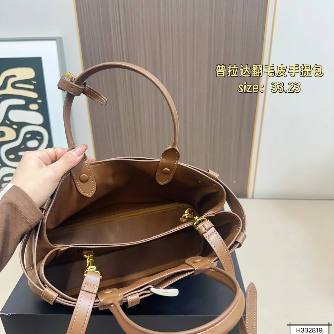 💰235 配盒⚠️尺寸33*23 Prada 普拉达 Buckle翻毛皮手提包 2024春夏系列，采用柔软麂皮，触感细腻，低调哑光质感超有氛围感。标志性金属腰带＋三角徽标，辨识度满分！尺寸适中中，通勤休闲都能轻松驾驱。肩带可拆卸调节，手提斜挎随心切换，实用又时髦。简约大气，时尚爱好者必入！