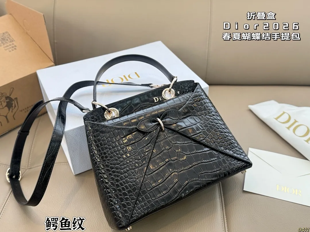 ¥300折叠盒 迪奥 Dior 2026春夏蝴蝶结手提包 质感细腻又耐用。正面立体蝴蝶结设计,优雅又俏皮,梯形包型容量适中,通勤休闲都很OK。顶部硬质手柄+可调节肩带,手提斜挎随心切换。 整体简约精致,法式浪漫氛围感拉满,是2026春夏系列超亮眼单品!尺寸28*19.5