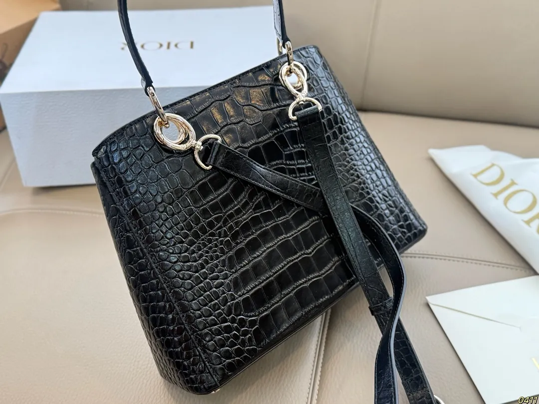 ¥300折叠盒 迪奥 Dior 2026春夏蝴蝶结手提包 质感细腻又耐用。正面立体蝴蝶结设计,优雅又俏皮,梯形包型容量适中,通勤休闲都很OK。顶部硬质手柄+可调节肩带,手提斜挎随心切换。 整体简约精致,法式浪漫氛围感拉满,是2026春夏系列超亮眼单品!尺寸28*19.5