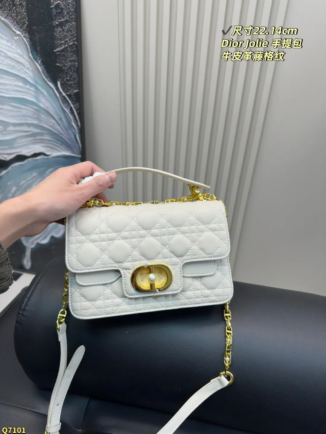 💰155配折叠盒 尺寸22.14cm 迪奥Dior Jolie 手提包是2025春夏成衣系列新品,兼具优雅气质与实用功能。采用黑色牛皮革精心制作,饰以藤格纹缉面线,双重翻盖饰以 CD 标志提升格调,点缀以白色树脂珠饰,三隔层和拉链口袋可收纳各种日常用品,可与日常或晚装造型搭配。小号款式,搭配可拆卸手柄与可拆卸链条肩带,肩带由皮革带和 CD 标志链环组成,饰以白色树脂珠饰,可舒适手提、肩背或斜挎。