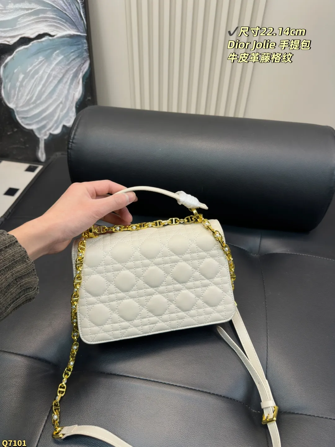 💰155配折叠盒 尺寸22.14cm 迪奥Dior Jolie 手提包是2025春夏成衣系列新品，兼具优雅气质与实用功能。采用黑色牛皮革精心制作，饰以藤格纹缉面线，双重翻盖饰以 CD 标志提升格调，点缀以白色树脂珠饰，三隔层和拉链口袋可收纳各种日常用品，可与日常或晚装造型搭配。小号款式，搭配可拆卸手柄与可拆卸链条肩带，肩带由皮革带和 CD 标志链环组成，饰以白色树脂珠饰，可舒适手提、肩背或斜挎。