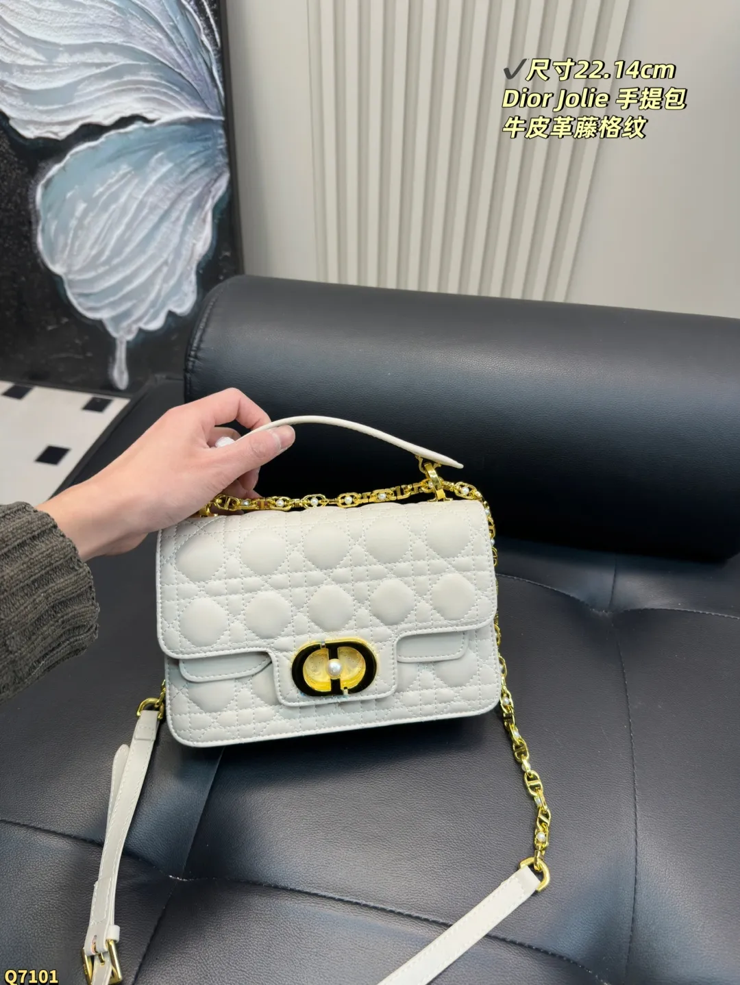 💰155配折叠盒 尺寸22.14cm 迪奥Dior Jolie 手提包是2025春夏成衣系列新品，兼具优雅气质与实用功能。采用黑色牛皮革精心制作，饰以藤格纹缉面线，双重翻盖饰以 CD 标志提升格调，点缀以白色树脂珠饰，三隔层和拉链口袋可收纳各种日常用品，可与日常或晚装造型搭配。小号款式，搭配可拆卸手柄与可拆卸链条肩带，肩带由皮革带和 CD 标志链环组成，饰以白色树脂珠饰，可舒适手提、肩背或斜挎。