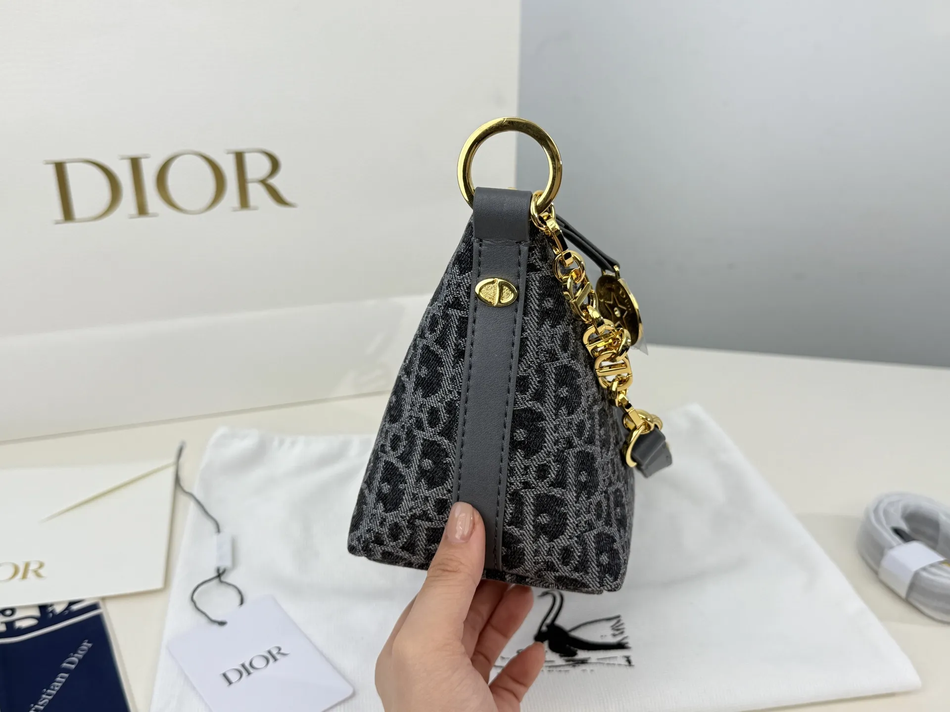 （折叠盒⚠️）p195 迪奥Dior 牛仔链条饭盒（自带延长带） 这款 Diorstar Hobo 链条手袋造型时尚，设计实用。采用蓝色 Denim Dior Oblique 提花面料精心制作，以不规则的石洗效果焕新演绎 Dior 的经典图案，彰显现代魅力，柔软版型搭配宽敞隔层。拉链开合，搭配镌刻以 Christian Dior Paris 标志和 Dior 经典星星标识的圆形饰牌，侧面饰以精致的 CD 铆钉，更显格调。内部带有绒面牛皮革里料，配有卡槽。搭配可调节的 CD 链条肩带，并带有皮革带，提升肩背时的舒适度。 size：22.16cm