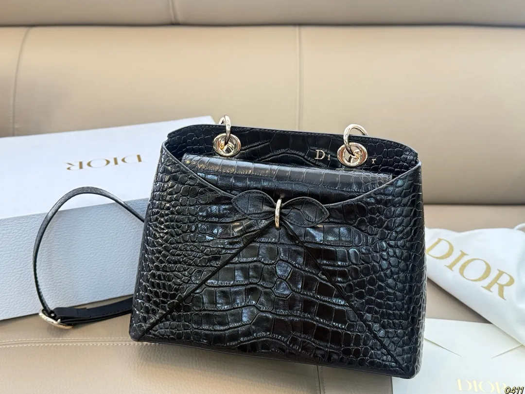 &yen;300折叠盒 迪奥 Dior 2026春夏蝴蝶结手提包 质感细腻又耐用。正面立体蝴蝶结设计，优雅又俏皮，梯形包型容量适中，通勤休闲都很OK。顶部硬质手柄＋可调节肩带，手提斜挎随心切换。 整体简约精致，法式浪漫氛围感拉满，是2026春夏系列超亮眼单品！尺寸28*19.5