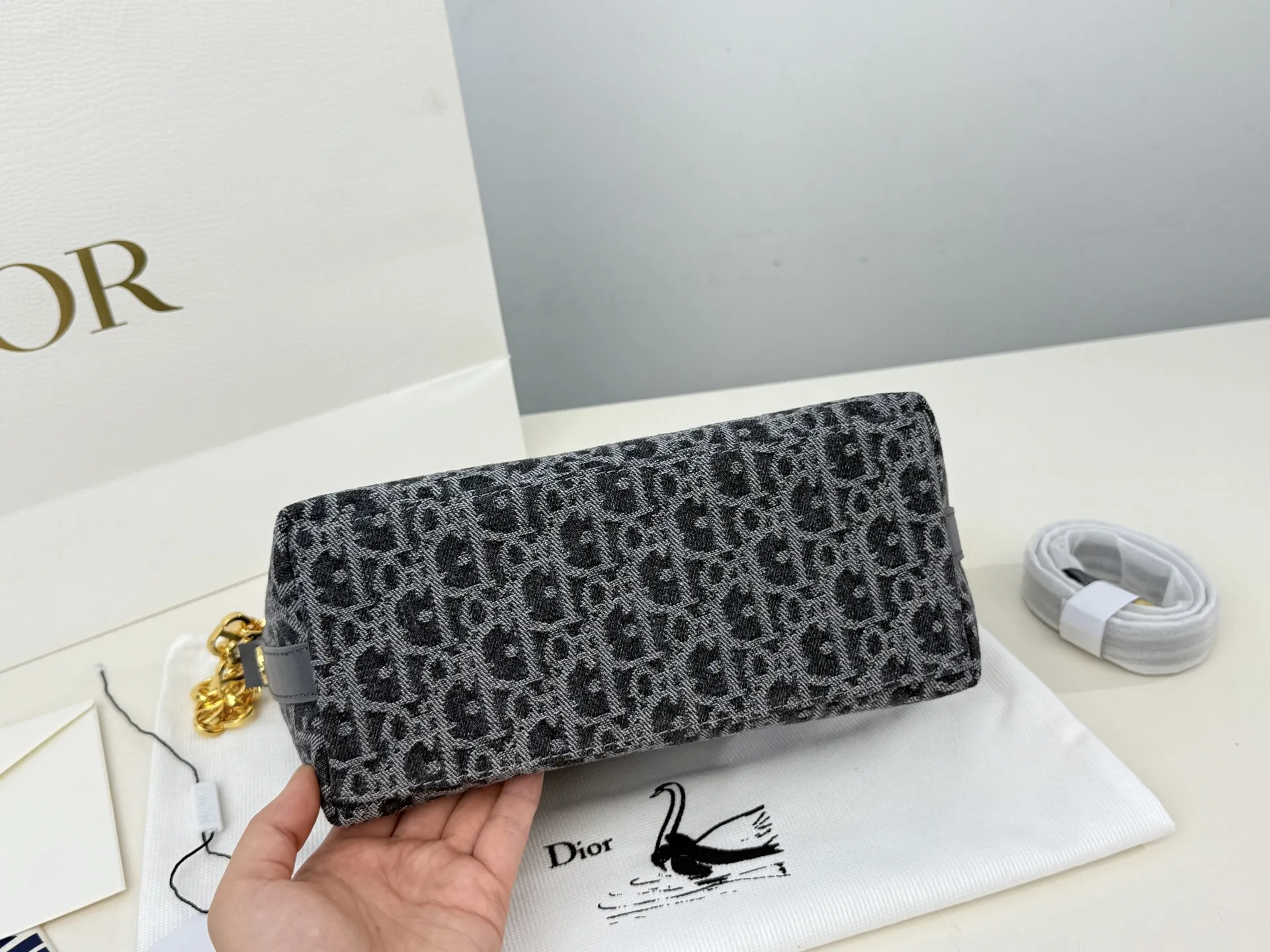 (折叠盒⚠️)p195 迪奥Dior 牛仔链条饭盒(自带延长带) 这款 Diorstar Hobo 链条手袋造型时尚,设计实用。采用蓝色 Denim Dior Oblique 提花面料精心制作,以不规则的石洗效果焕新演绎 Dior 的经典图案,彰显现代魅力,柔软版型搭配宽敞隔层。拉链开合,搭配镌刻以 Christian Dior Paris 标志和 Dior 经典星星标识的圆形饰牌,侧面饰以精致的 CD 铆钉,更显格调。内部带有绒面牛皮革里料,配有卡槽。搭配可调节的 CD 链条肩带,并带有皮革带,提升肩背时的舒适度。 size:22.16cm