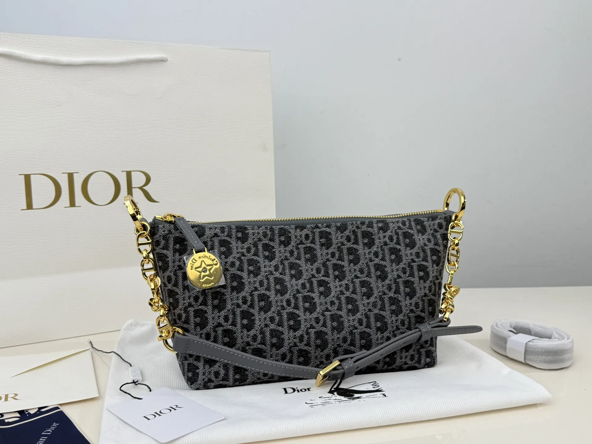 (折叠盒⚠️)p195 迪奥Dior 牛仔链条饭盒(自带延长带) 这款 Diorstar Hobo 链条手袋造型时尚,设计实用。采用蓝色 Denim Dior Oblique 提花面料精心制作,以不规则的石洗效果焕新演绎 Dior 的经典图案,彰显现代魅力,柔软版型搭配宽敞隔层。拉链开合,搭配镌刻以 Christian Dior Paris 标志和 Dior 经典星星标识的圆形饰牌,侧面饰以精致的 CD 铆钉,更显格调。内部带有绒面牛皮革里料,配有卡槽。搭配可调节的 CD 链条肩带,并带有皮革带,提升肩背时的舒适度。 size:22.16cm