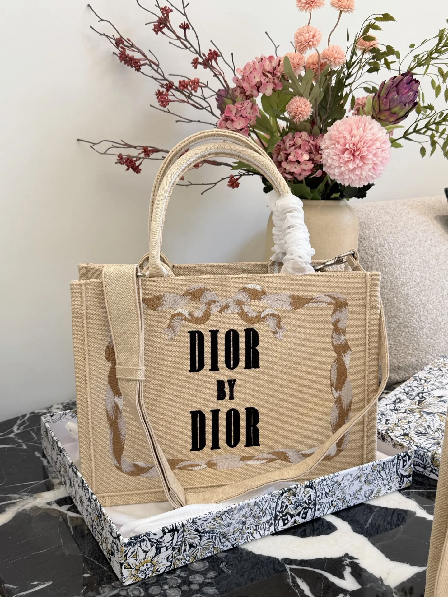 p200p235 顶级原单 从经典Book Tote的新面貌,到带有复古质感的斜挎包、手拿包,每一款都融合了迪奥的高雅基因与Jonathan Anderson独有的创意视角。 在保留品牌标志性廓形的基础上,注入更轻盈、更具功能性的细节设计。小型手袋则以层次感织物与全新迪奥LOGO提升辨识度,展现刚柔并济的现代风格。 25cm36cm配盒子