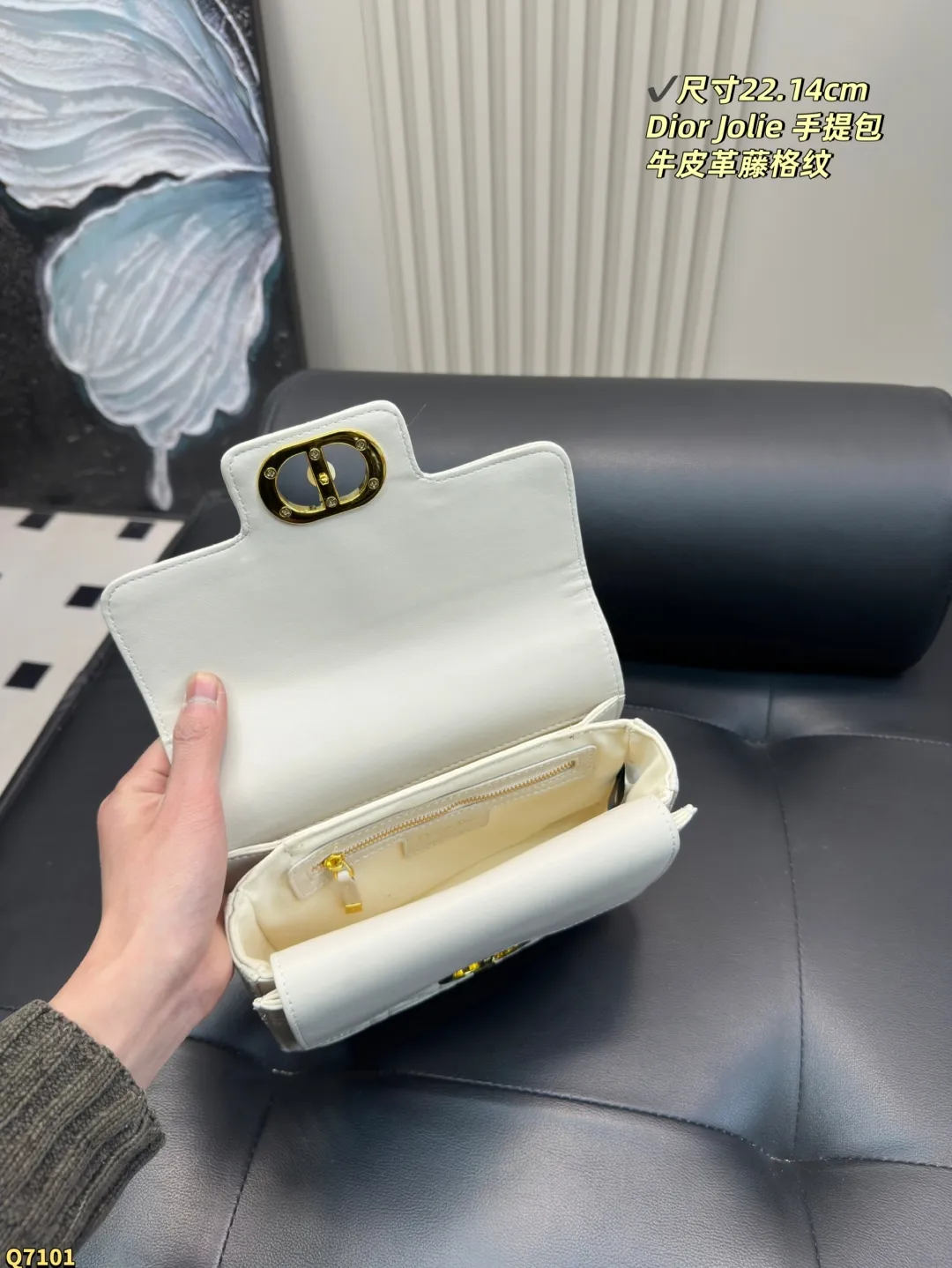 💰155配折叠盒 尺寸22.14cm 迪奥Dior Jolie 手提包是2025春夏成衣系列新品，兼具优雅气质与实用功能。采用黑色牛皮革精心制作，饰以藤格纹缉面线，双重翻盖饰以 CD 标志提升格调，点缀以白色树脂珠饰，三隔层和拉链口袋可收纳各种日常用品，可与日常或晚装造型搭配。小号款式，搭配可拆卸手柄与可拆卸链条肩带，肩带由皮革带和 CD 标志链环组成，饰以白色树脂珠饰，可舒适手提、肩背或斜挎。