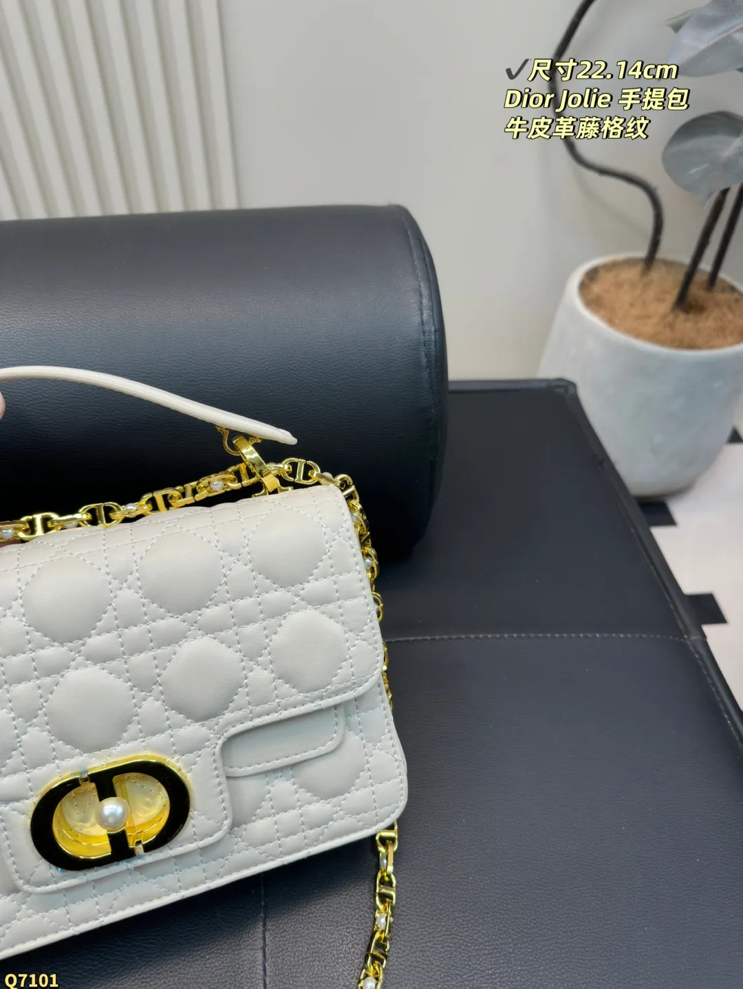 💰155配折叠盒 尺寸22.14cm 迪奥Dior Jolie 手提包是2025春夏成衣系列新品，兼具优雅气质与实用功能。采用黑色牛皮革精心制作，饰以藤格纹缉面线，双重翻盖饰以 CD 标志提升格调，点缀以白色树脂珠饰，三隔层和拉链口袋可收纳各种日常用品，可与日常或晚装造型搭配。小号款式，搭配可拆卸手柄与可拆卸链条肩带，肩带由皮革带和 CD 标志链环组成，饰以白色树脂珠饰，可舒适手提、肩背或斜挎。