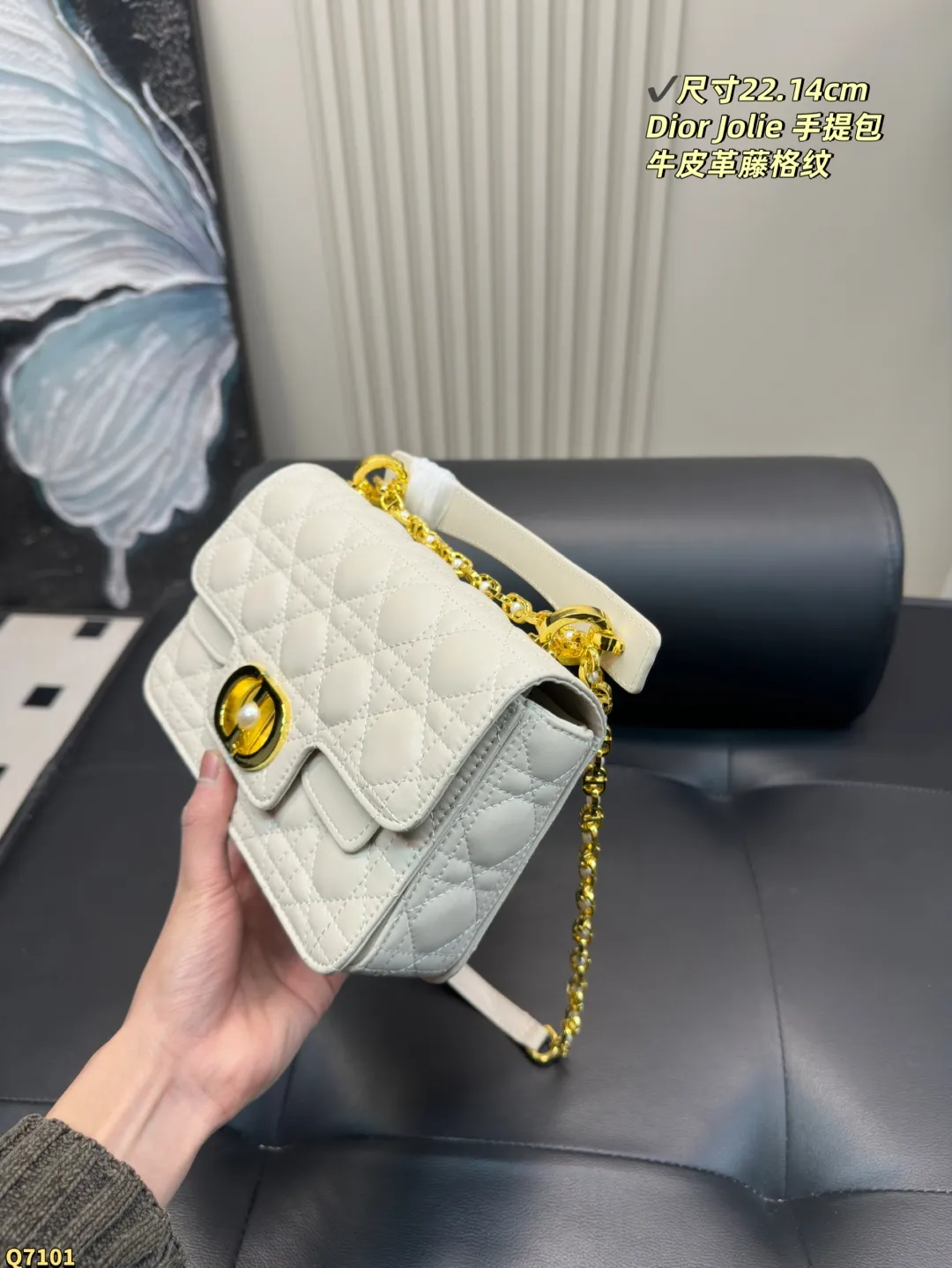 💰155配折叠盒 尺寸22.14cm 迪奥Dior Jolie 手提包是2025春夏成衣系列新品,兼具优雅气质与实用功能。采用黑色牛皮革精心制作,饰以藤格纹缉面线,双重翻盖饰以 CD 标志提升格调,点缀以白色树脂珠饰,三隔层和拉链口袋可收纳各种日常用品,可与日常或晚装造型搭配。小号款式,搭配可拆卸手柄与可拆卸链条肩带,肩带由皮革带和 CD 标志链环组成,饰以白色树脂珠饰,可舒适手提、肩背或斜挎。